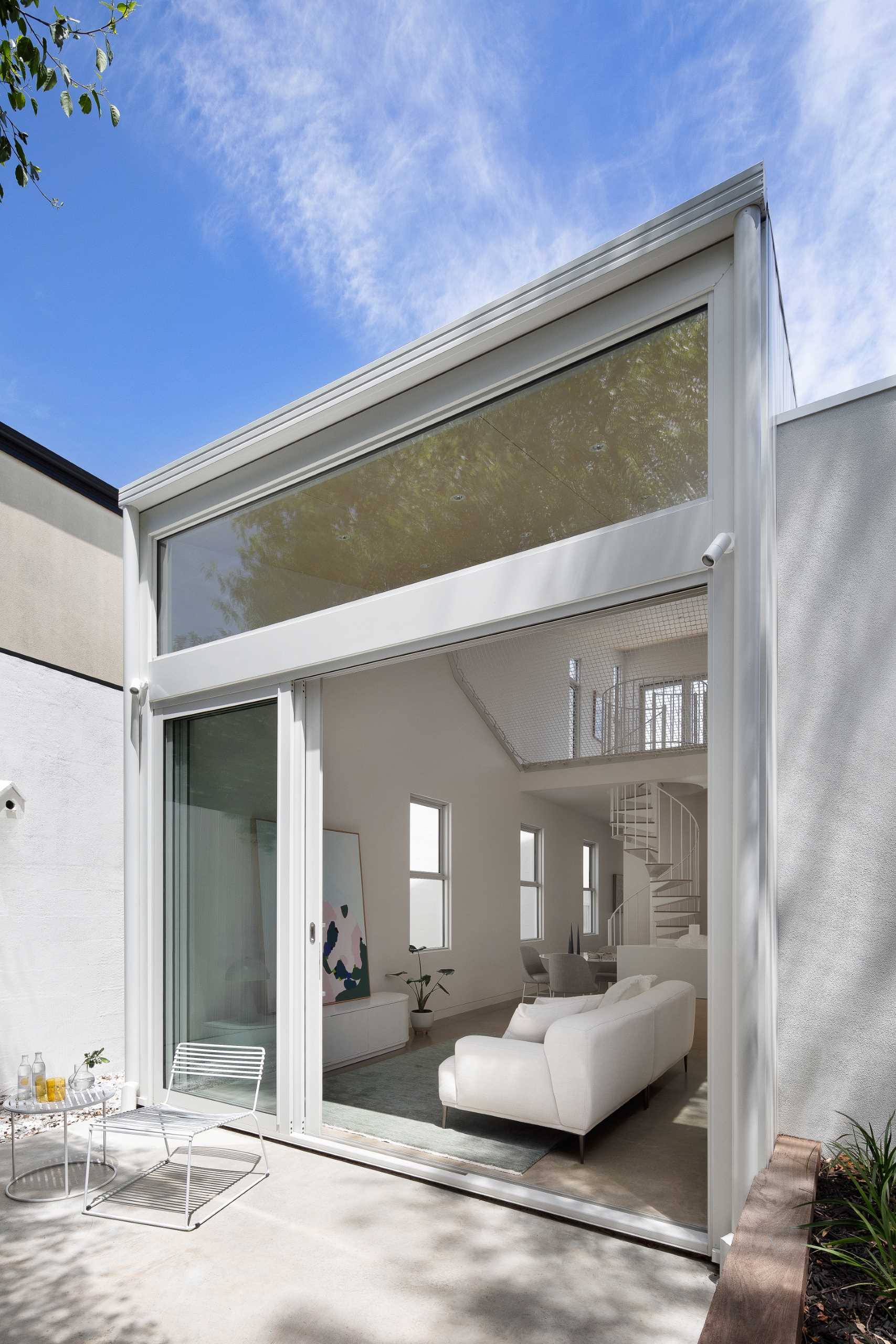 The double-height rear extension has sliding glass doors that connect the living room to the yard.