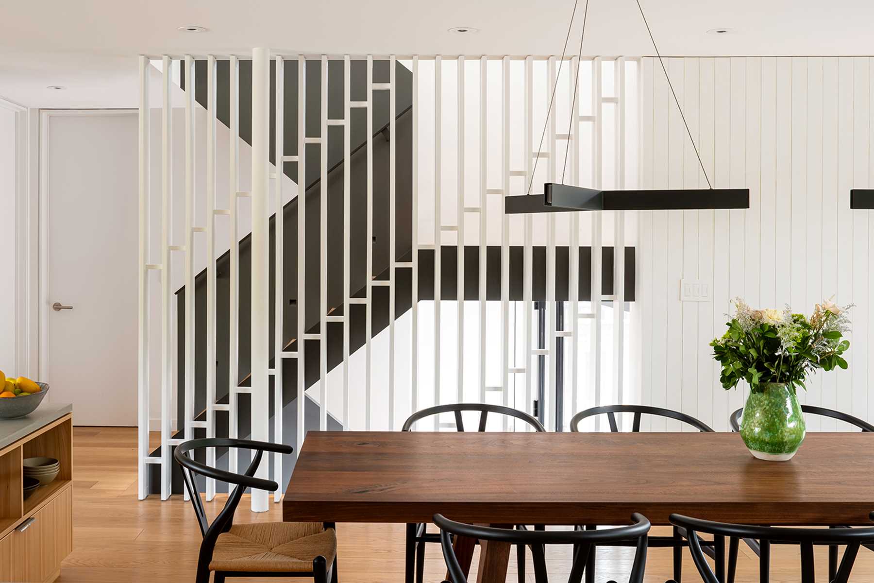 Modern black and wood stairs with a white partition wall.