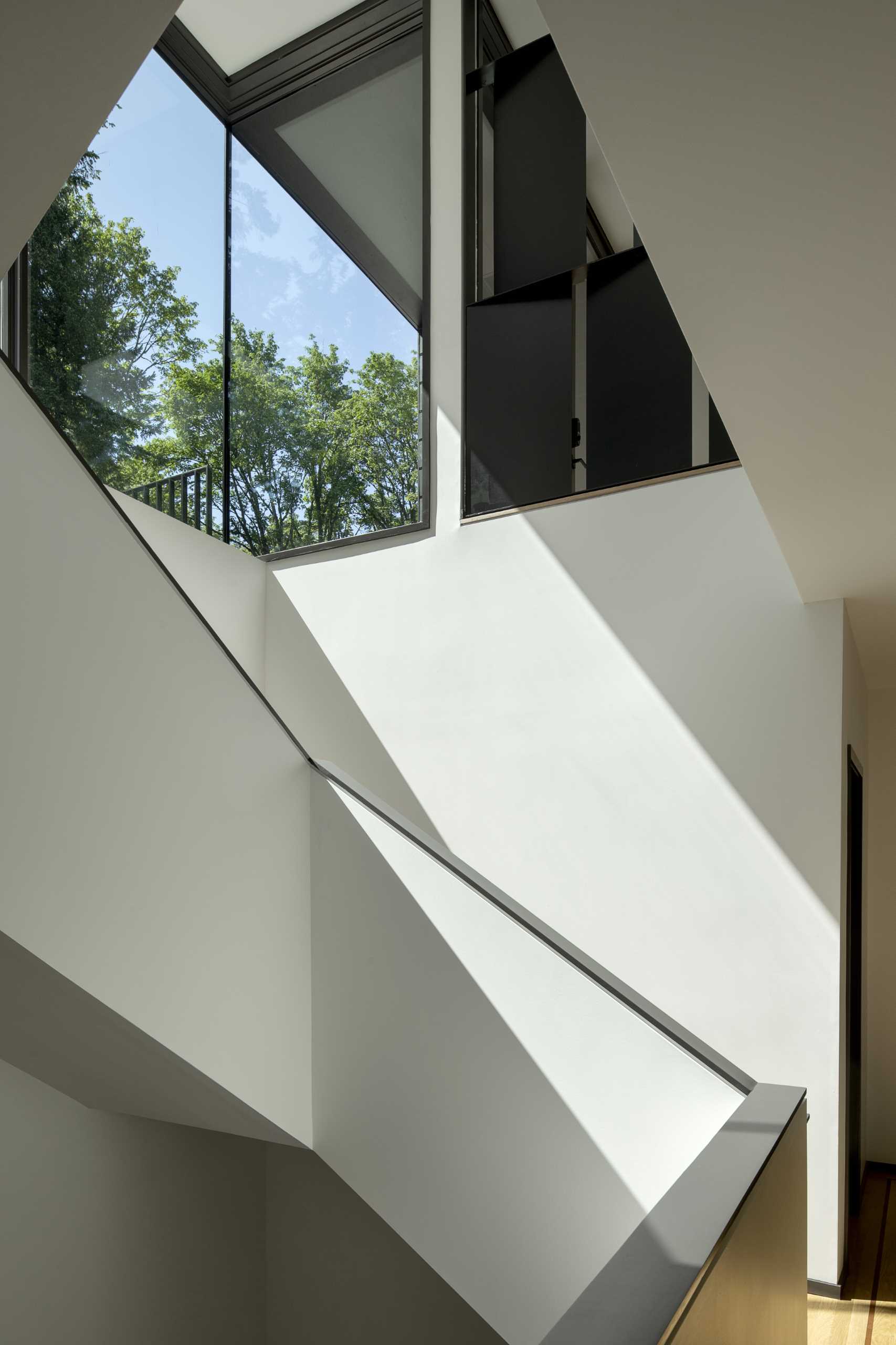 Stairs connect the multiple levels of this modern home with a black exterior.