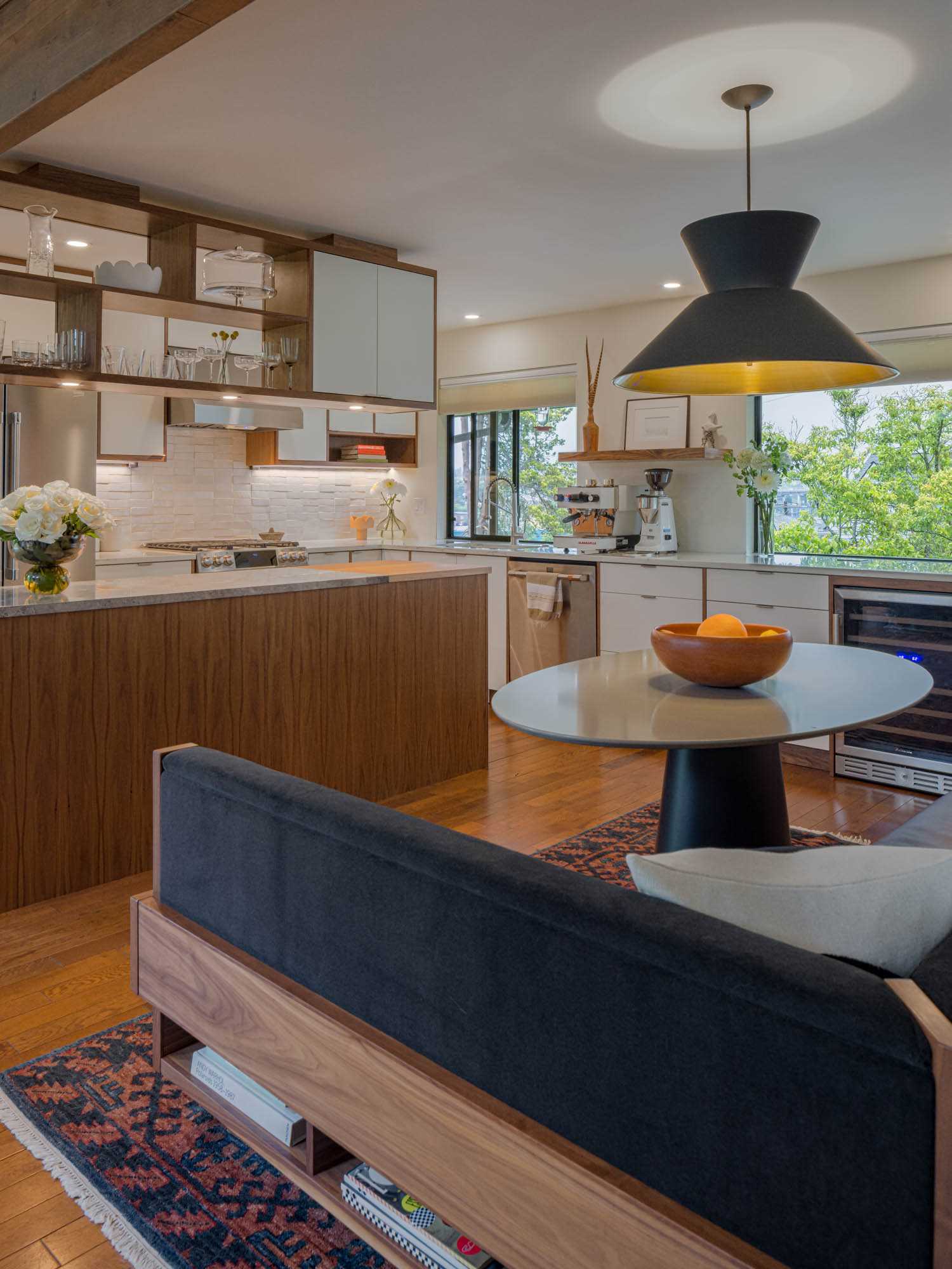 A remodeled kitchen with white cabinets and walnut details.