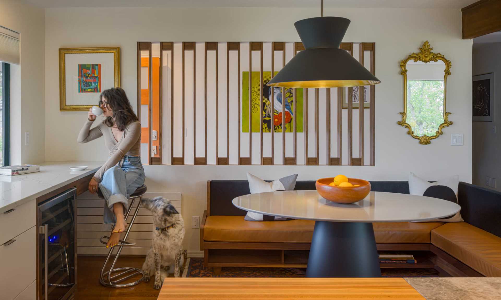 A modern dining area with custom banquette seating and a walnut screen.