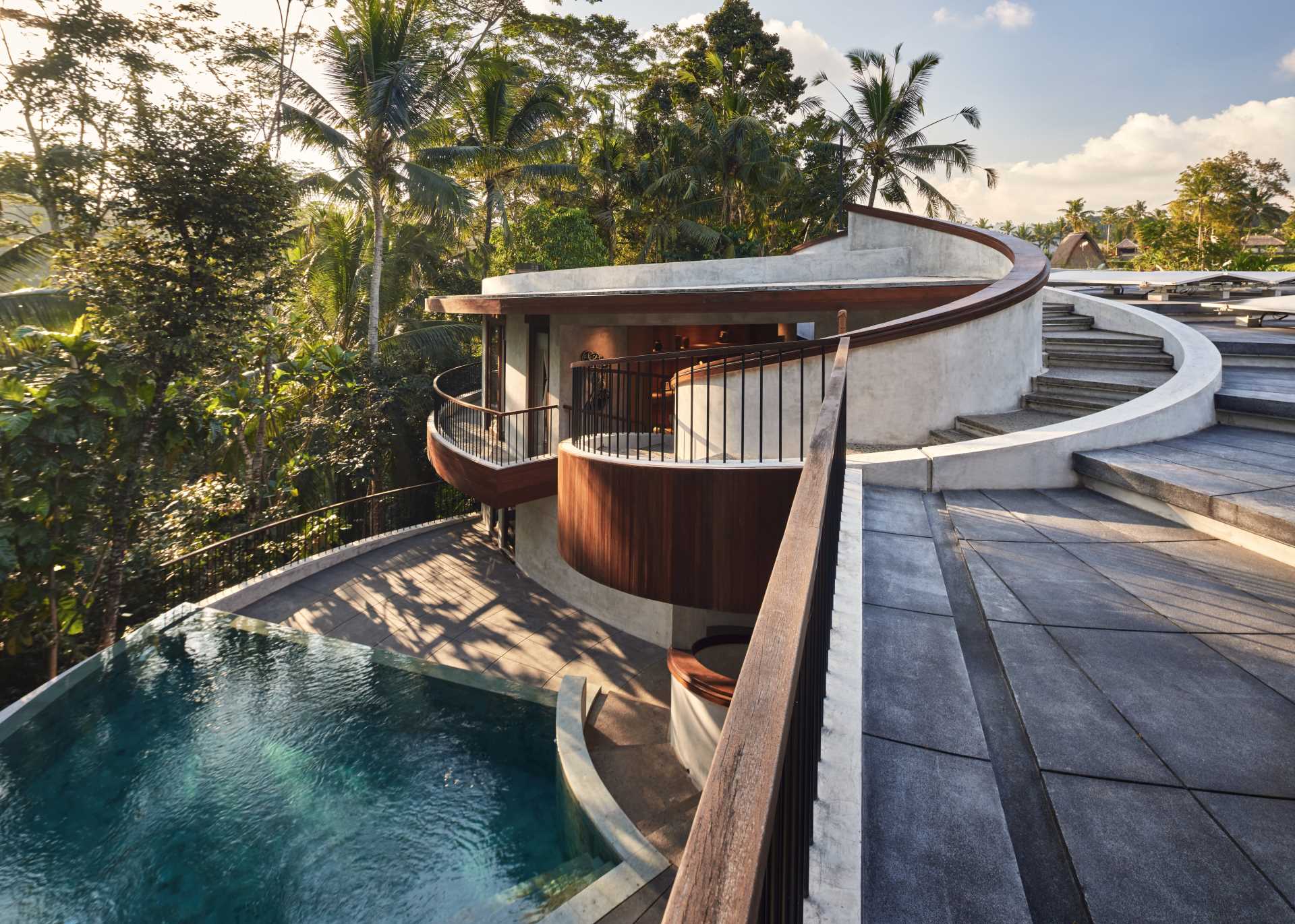 A modern home with spiral stairs that lead to the roof, where solar panels and sitting areas can be found.