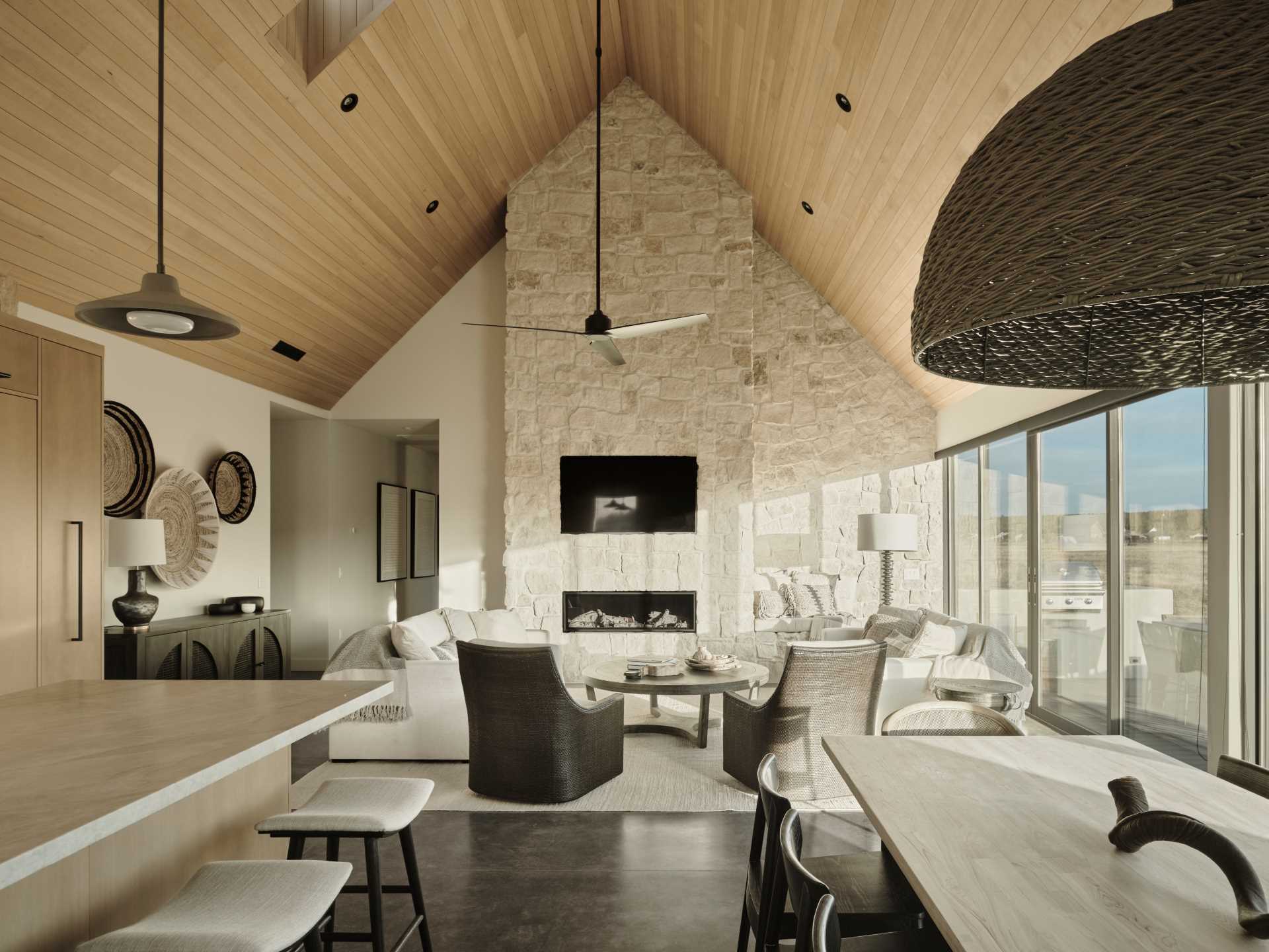 The interior of the home is a strong contrast to the exterior, with the stone fireplace in the living room drawing the eye upward to the wood-lined ceiling.