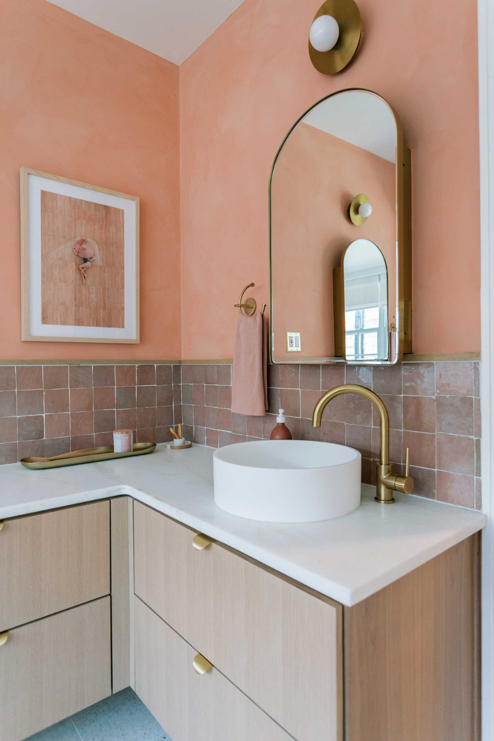 A contemporary bathroom renovation received a new corner vanity with double sinks, new tiles, and colorful walls.