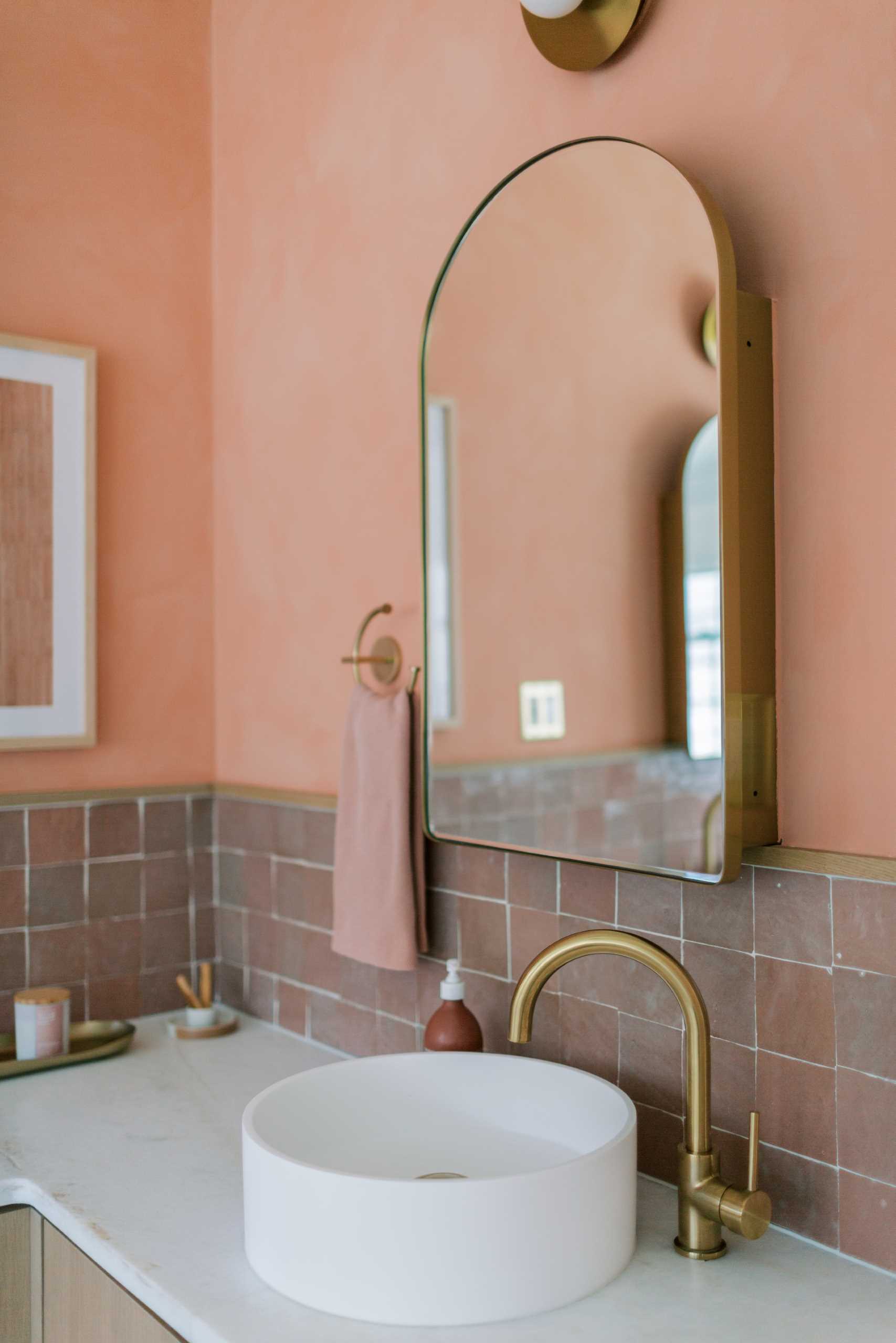 A contemporary bathroom renovation received a new corner vanity with double sinks, new tiles, and colorful walls.