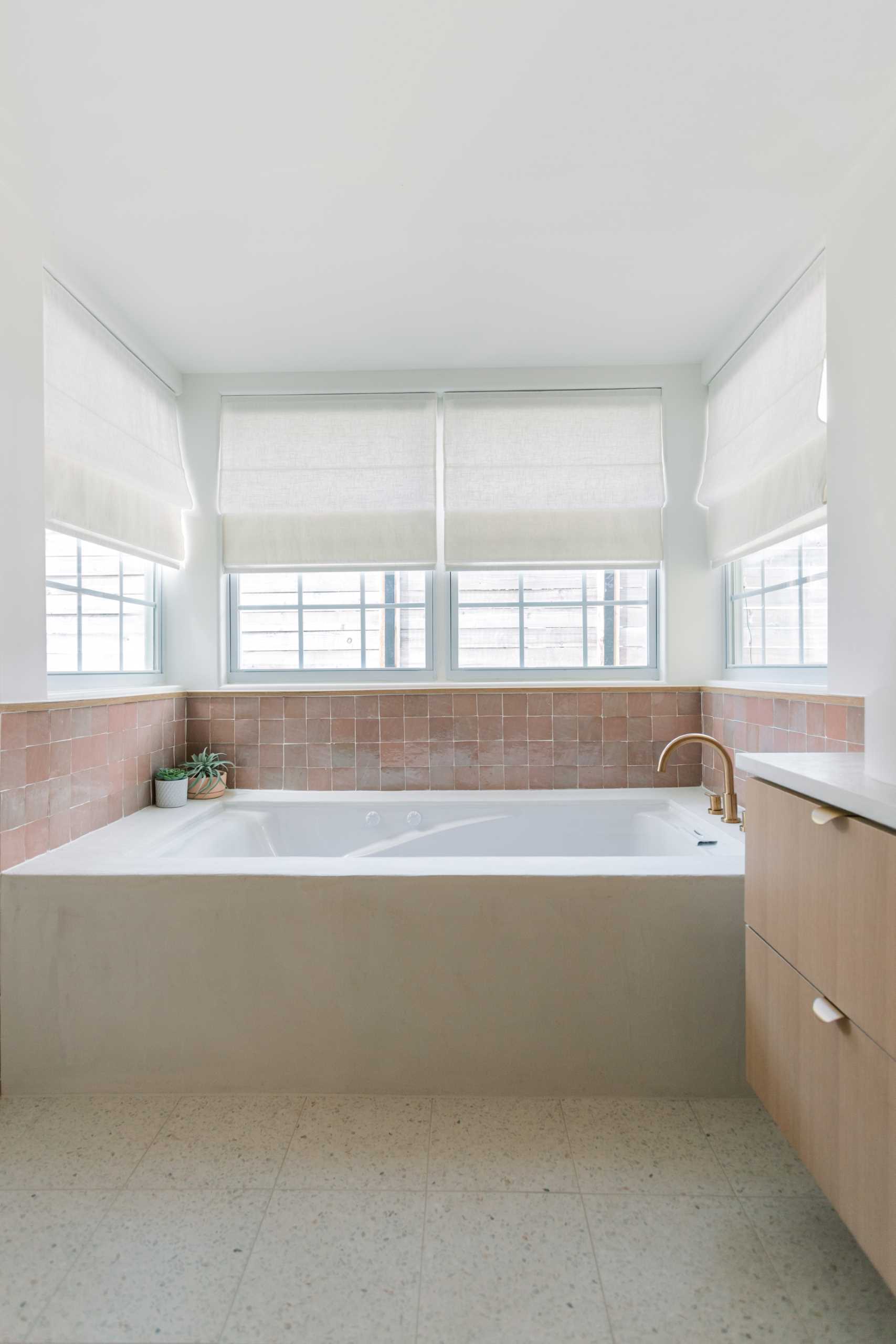 A contemporary bathroom with built-in bathtub and zellige tile surround.