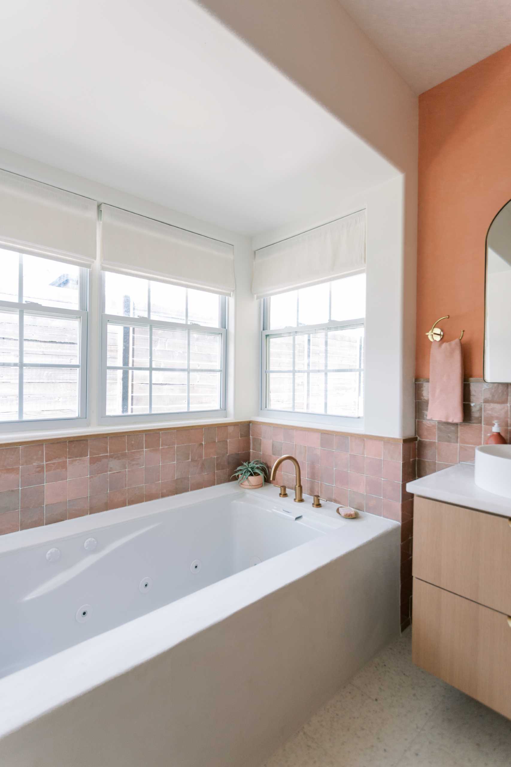 A contemporary bathroom with built-in bathtub and zellige tile surround.