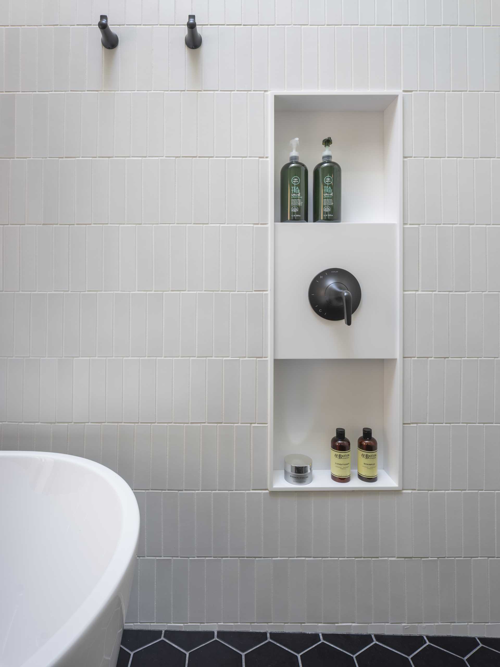 The primary bathroom has a hexagonal tile floor and a skylit wet zone containing the shower and tub.