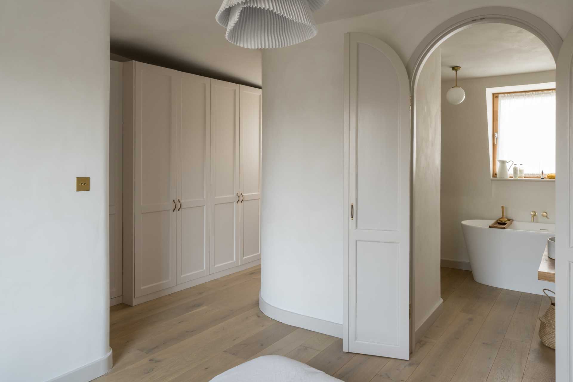 A contemporary primary bedroom suite with a wall of closets and an suite bathroom.