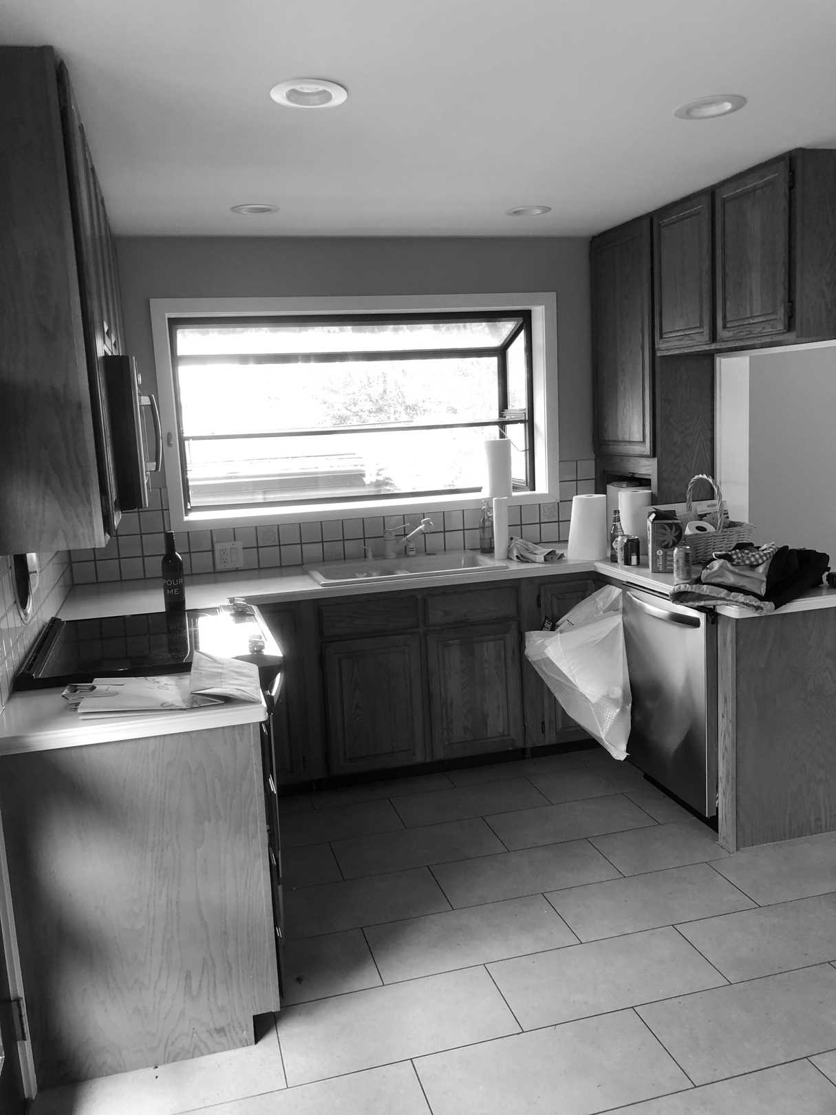 Before - The original kitchen was closed off and featured dated wood cabinets.