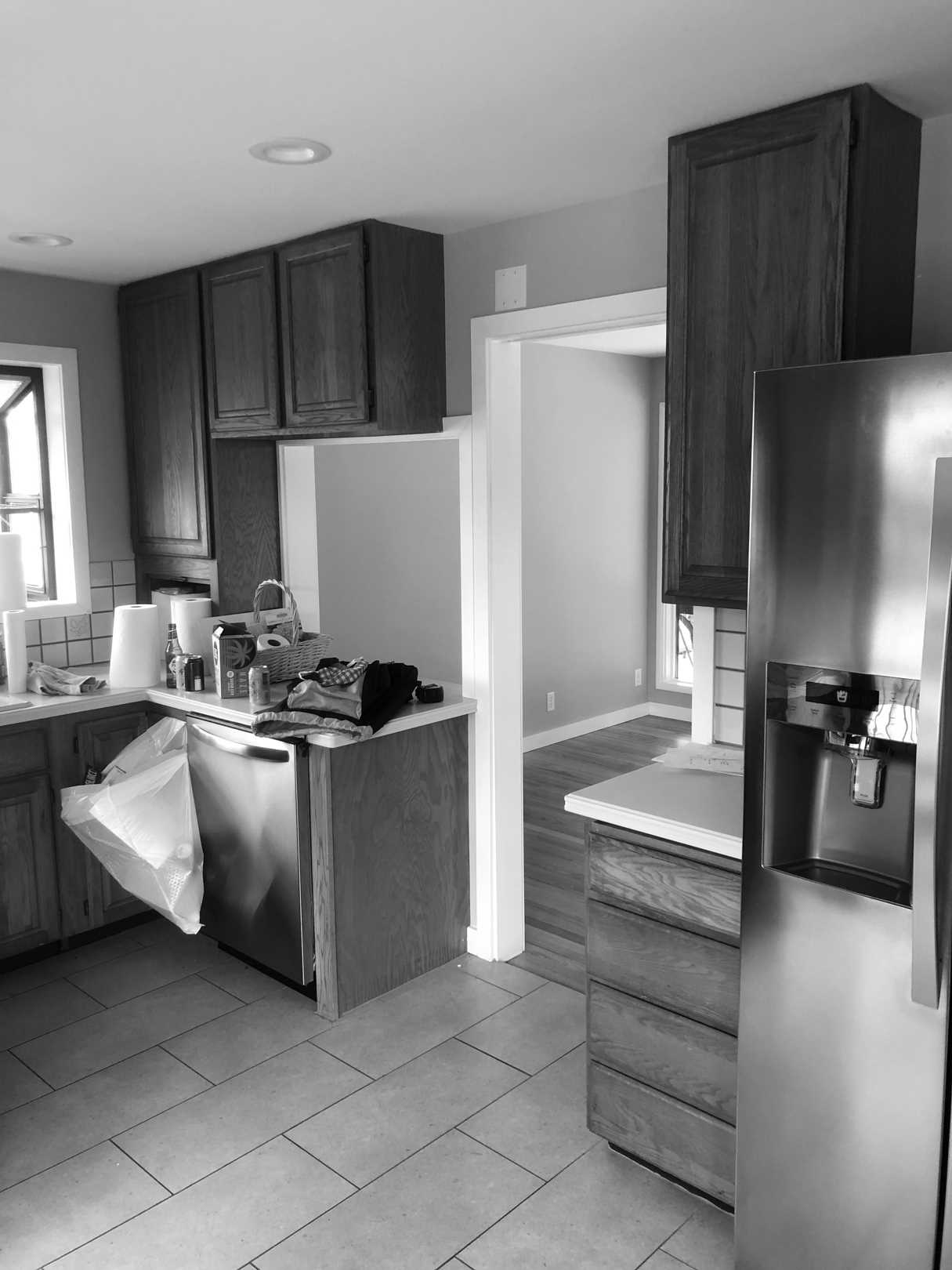 Before - The original kitchen was closed off and featured dated wood cabinets.