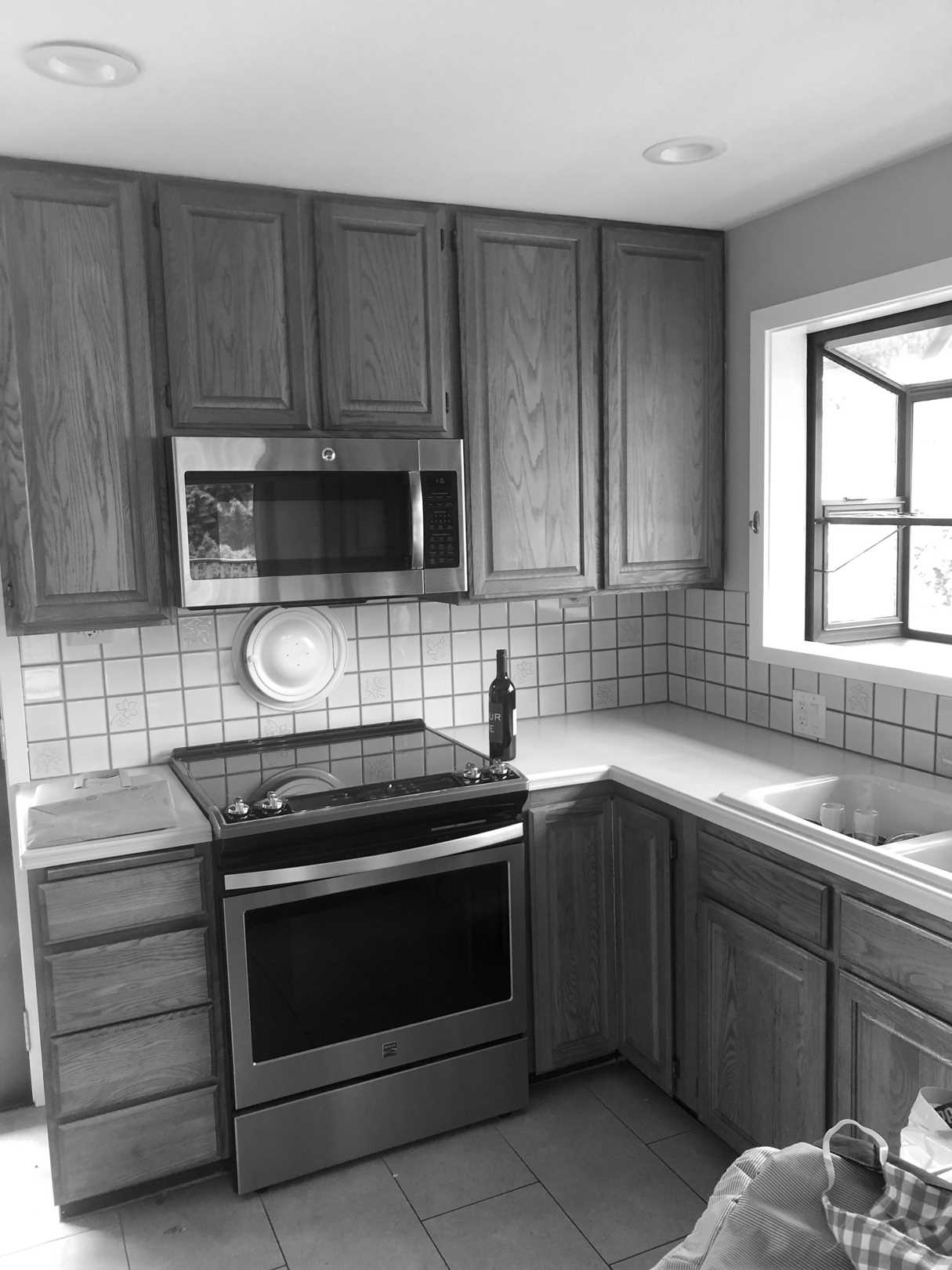 Before - The original kitchen was closed off and featured dated wood cabinets.