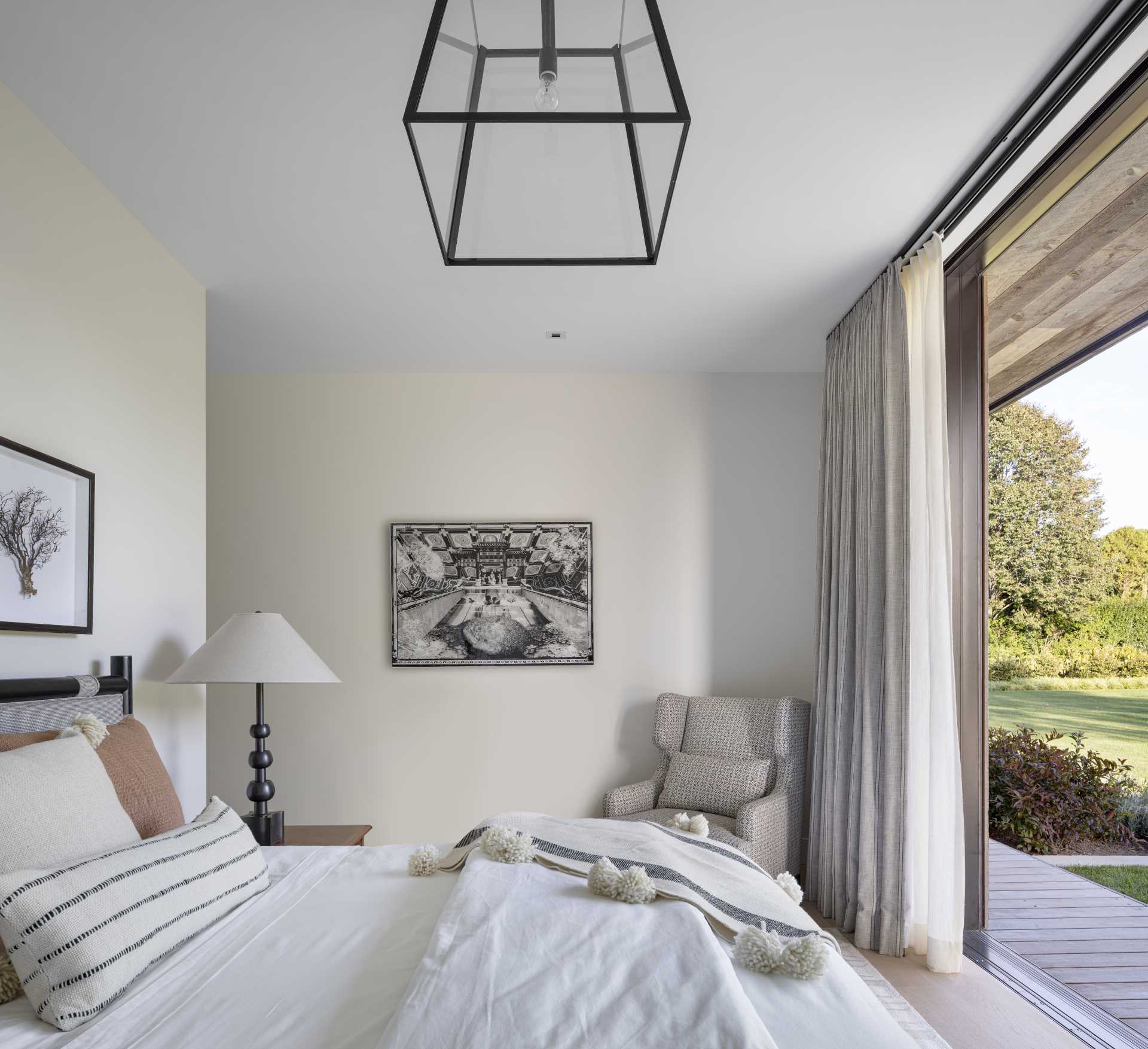 A contemporary bedroom with a sliding door that opens to the outdoors.