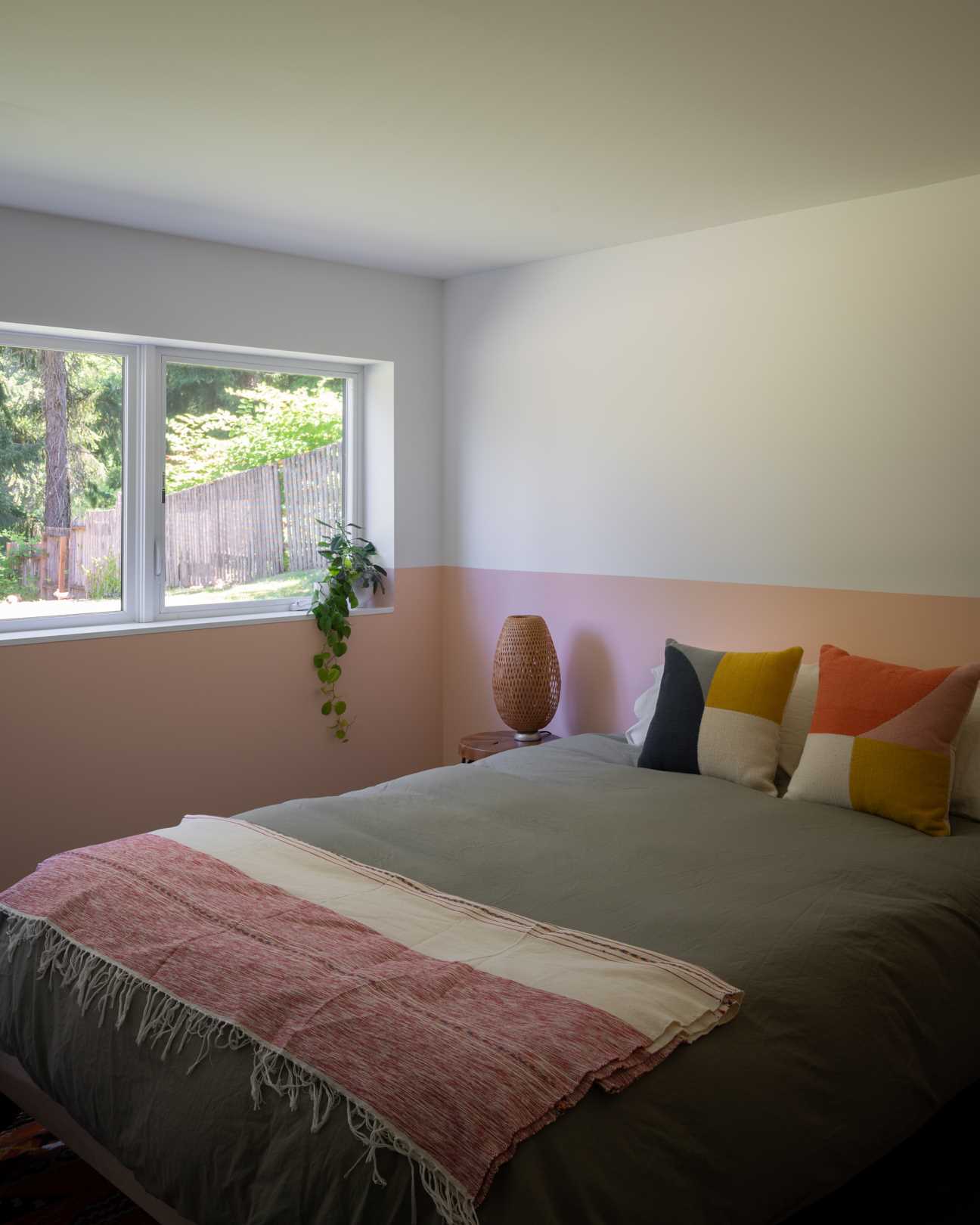 A contemporary bedroom with a colorful pink wraparound accent.