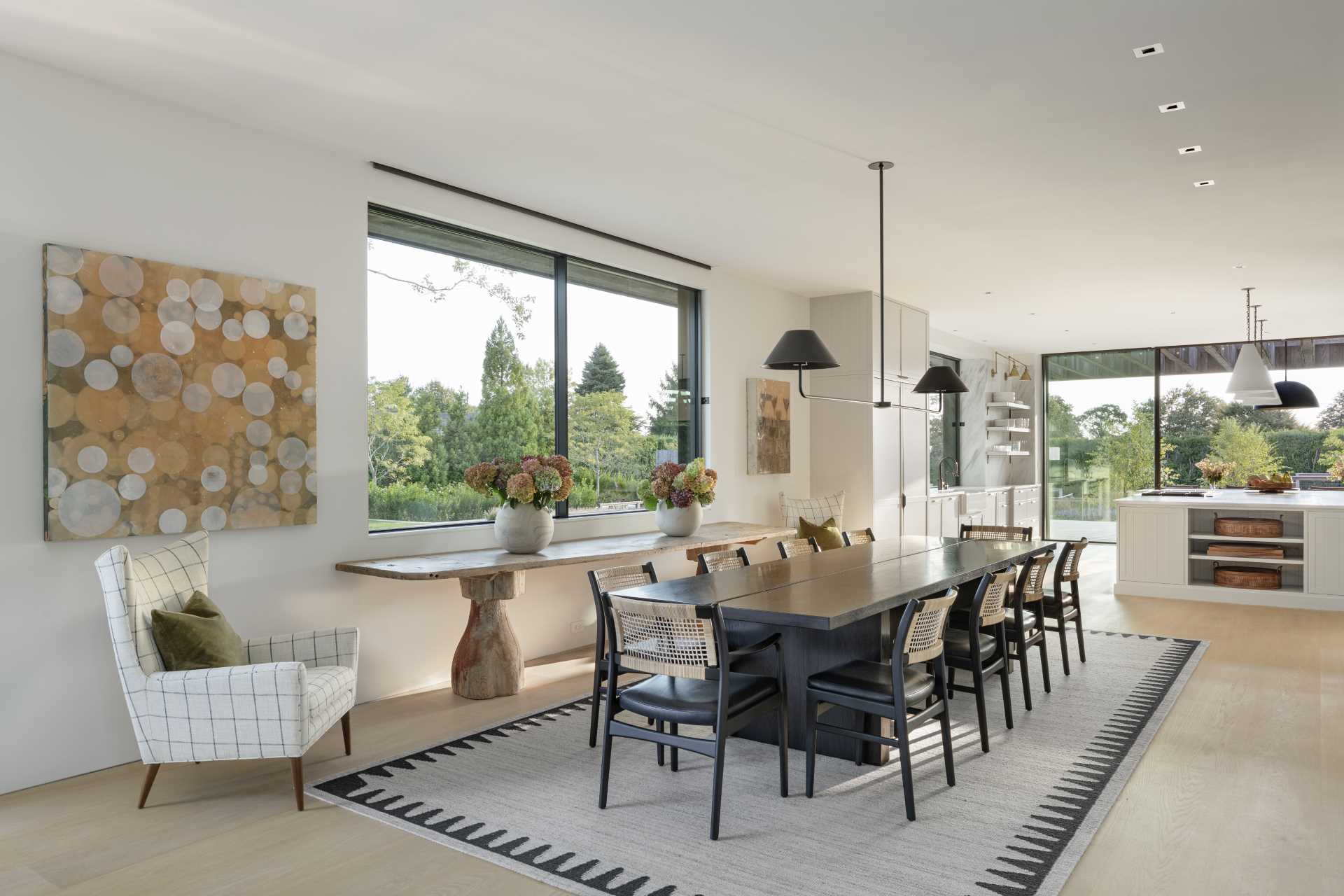 A contemporary open plan dining room with a large rug that defines the dining area.