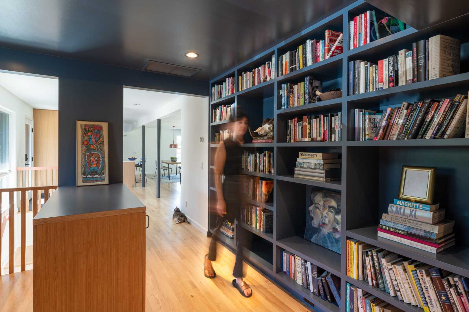 The updated hallway has been transformed into a walk-through library and home office, with plenty of storage for books and a built-in desk beneath the window.