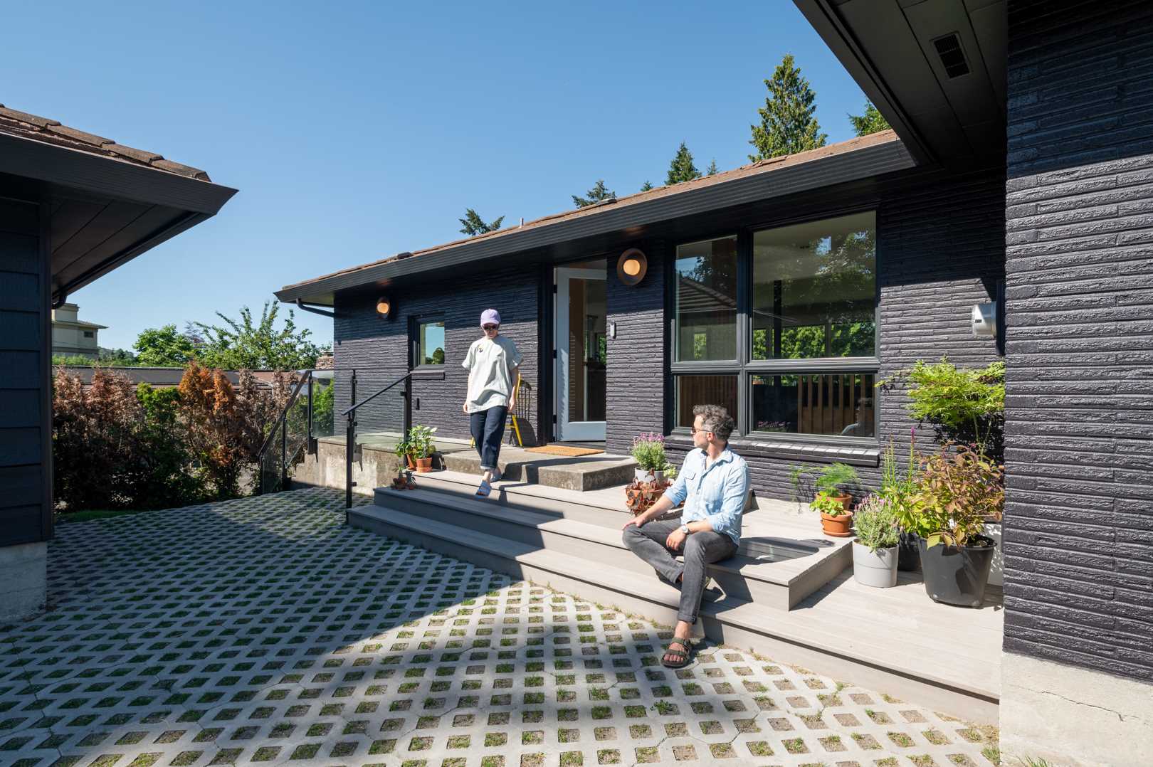 This updated facade has been opened up, with wide steps leading to a single front door. The exterior has been painted and potted plants have been added.