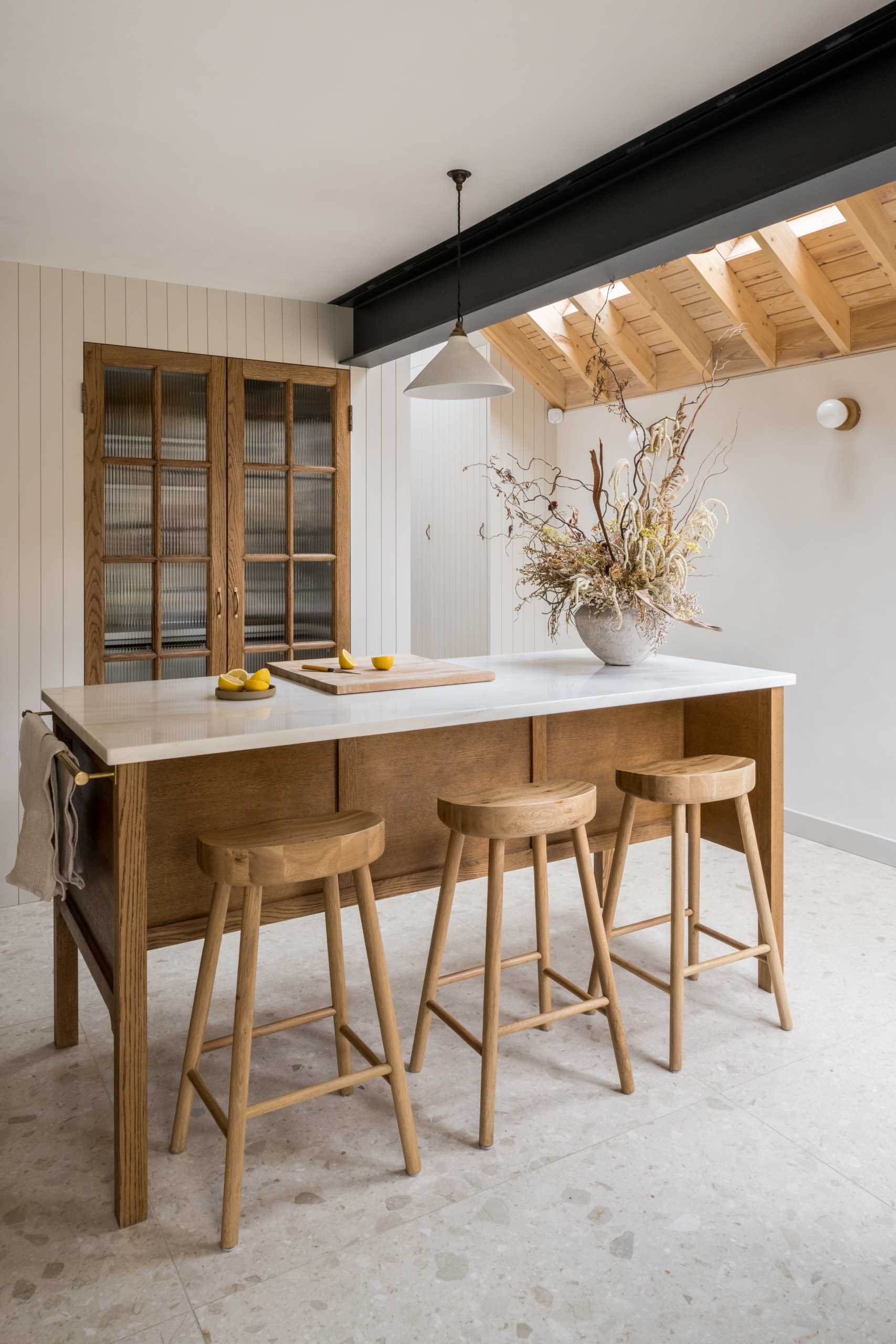 In this kitchen, the pantry doors open directly out onto the multi-functioning marble-topped preparation island.