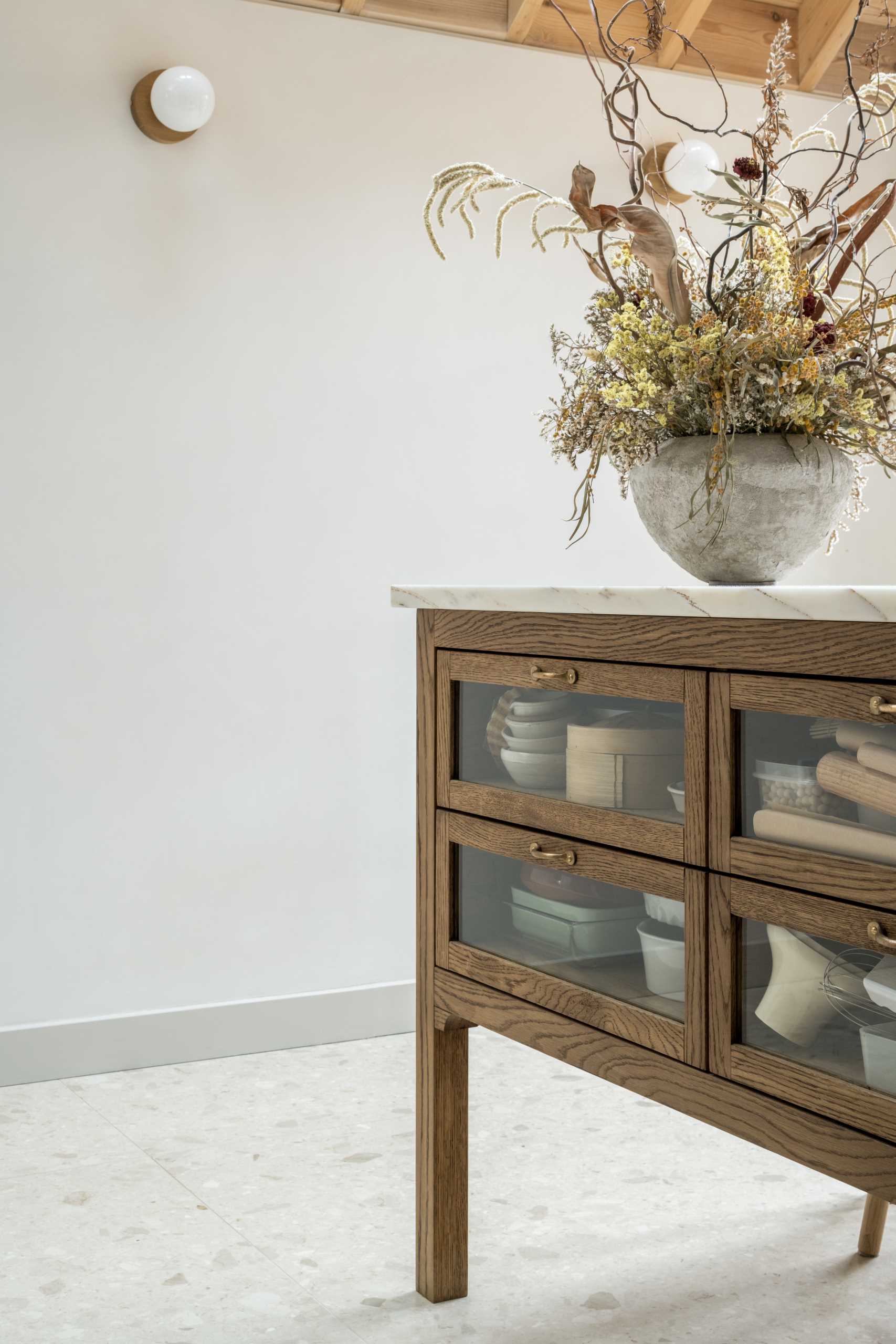 In this kitchen, the pantry doors open directly out onto the multi-functioning marble-topped preparation island.