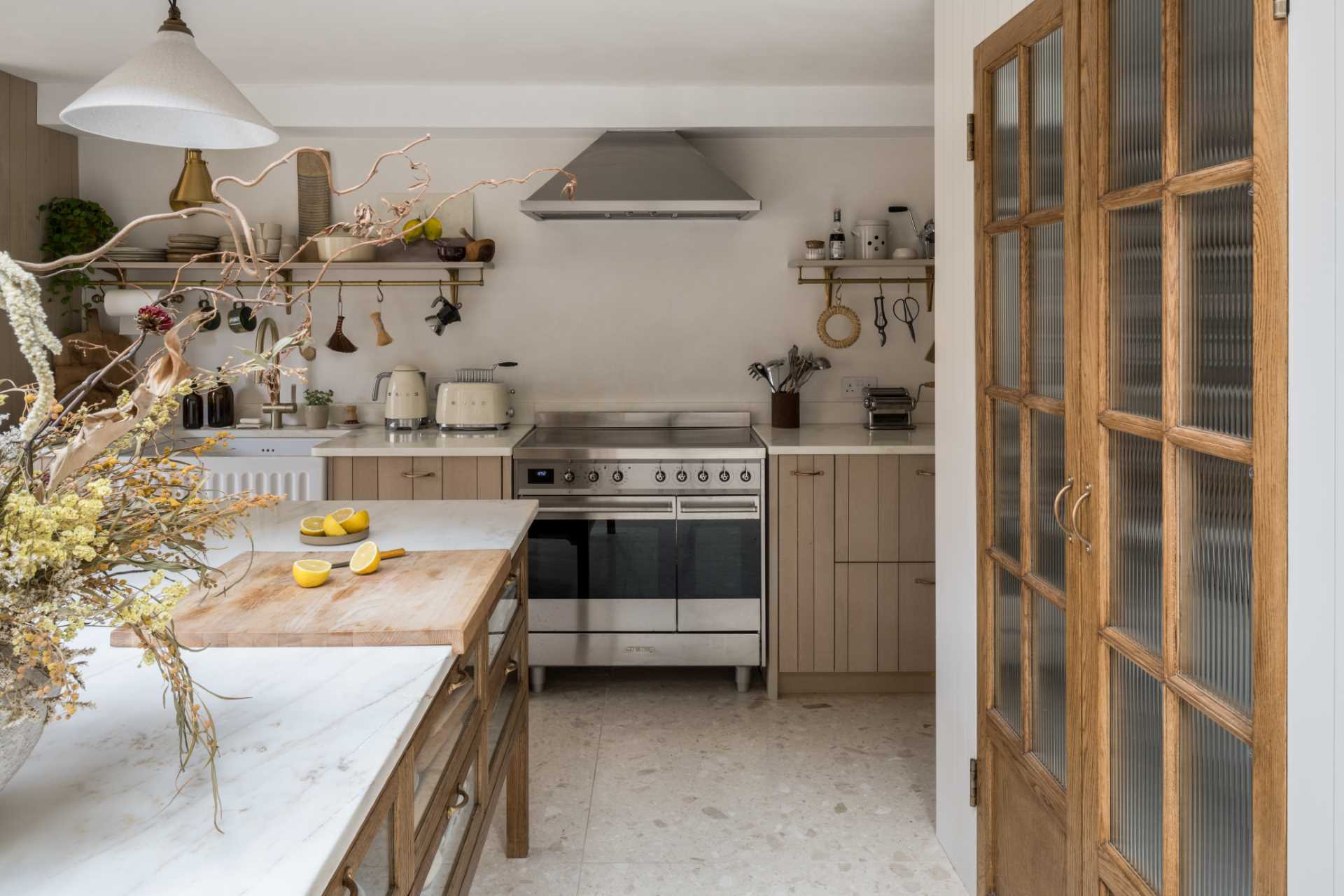 In this kitchen, the pantry doors open directly out onto the multi-functioning marble-topped preparation island.