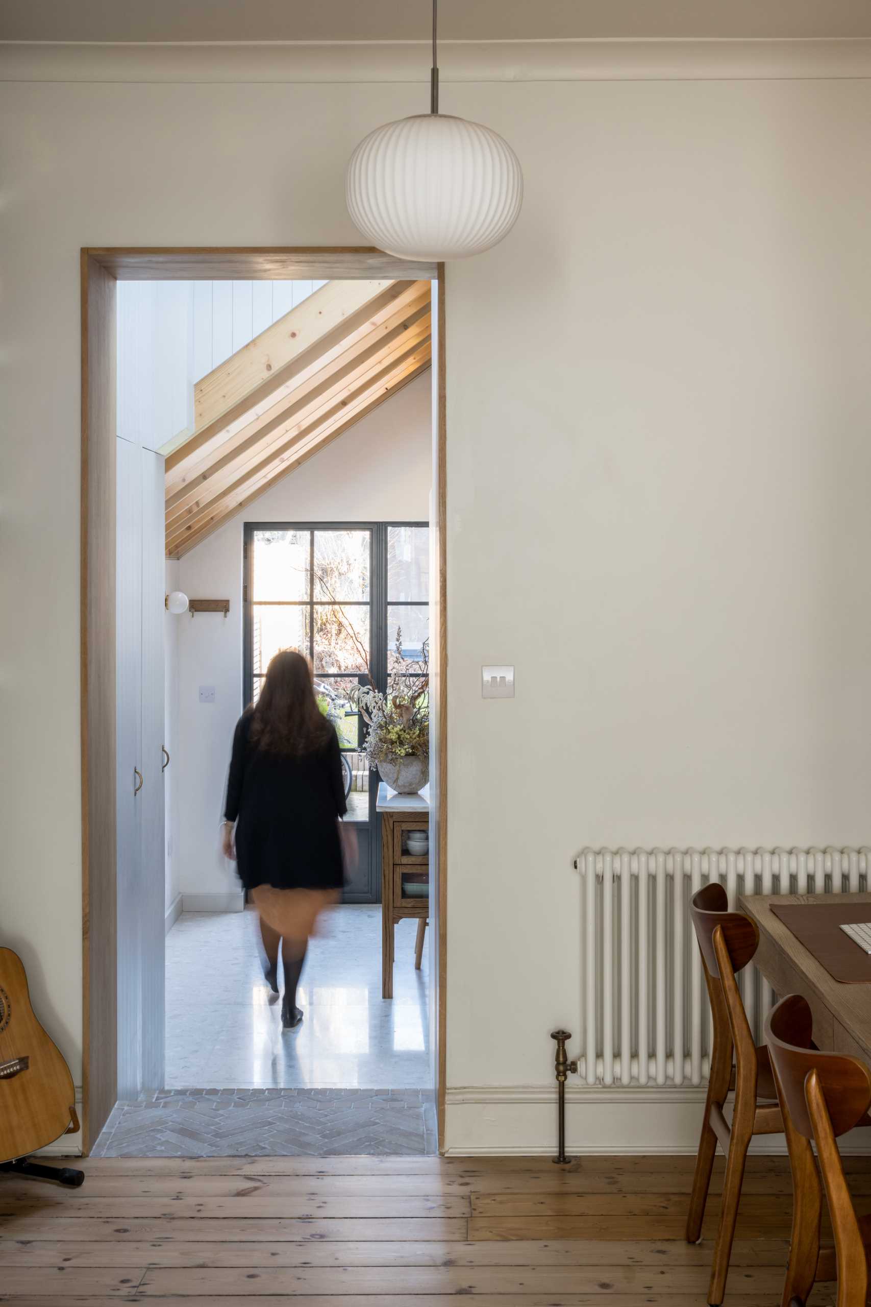 A wood-lined doorway complements the wood joists in the next room.