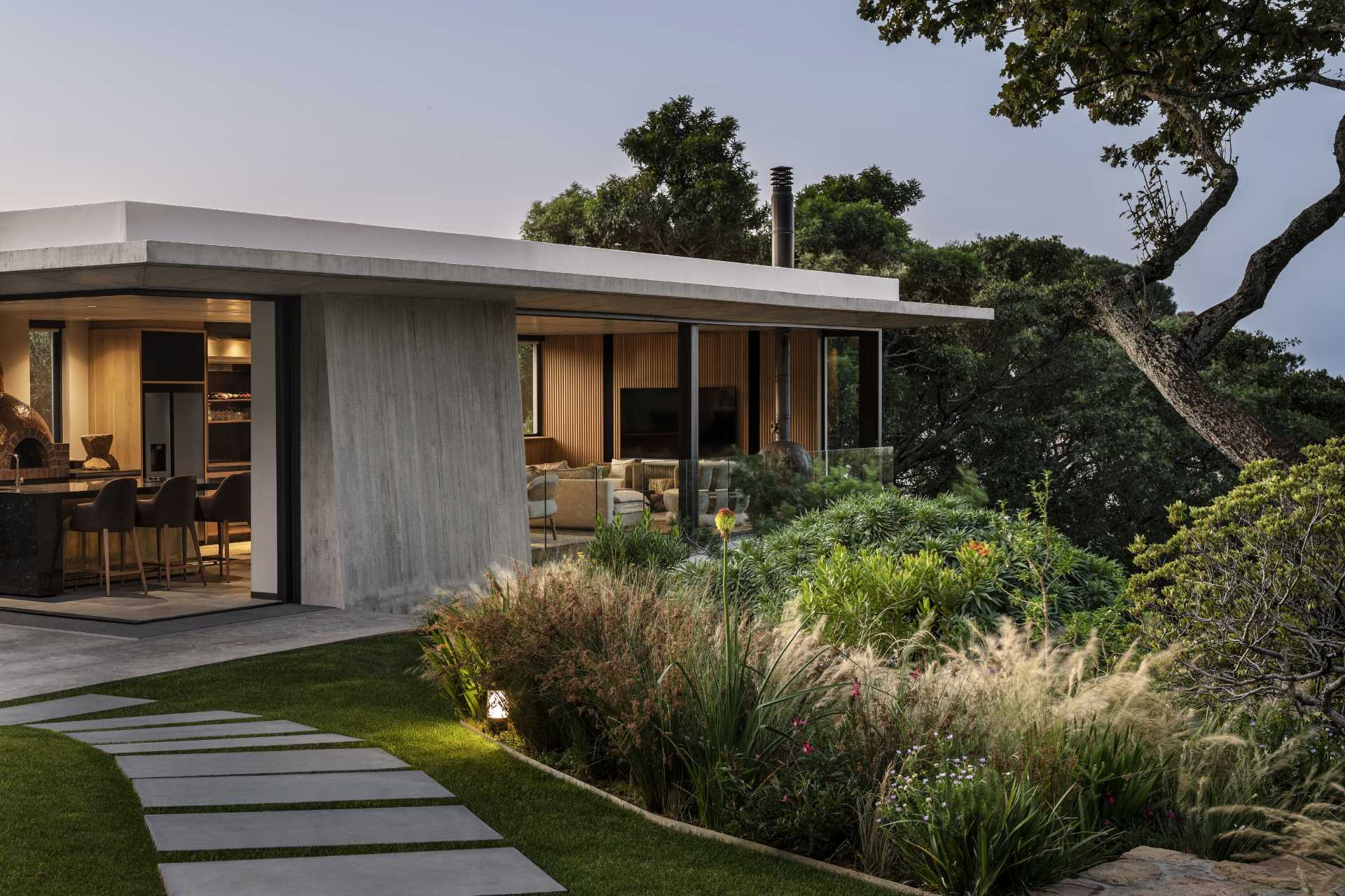 A modern garden pavilion with a kitchen, living room, and dining area.