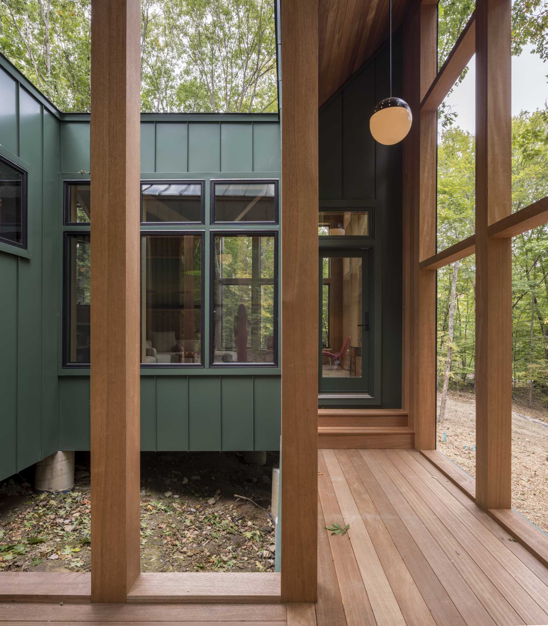 A modern cabin with a covered porch and central open area.