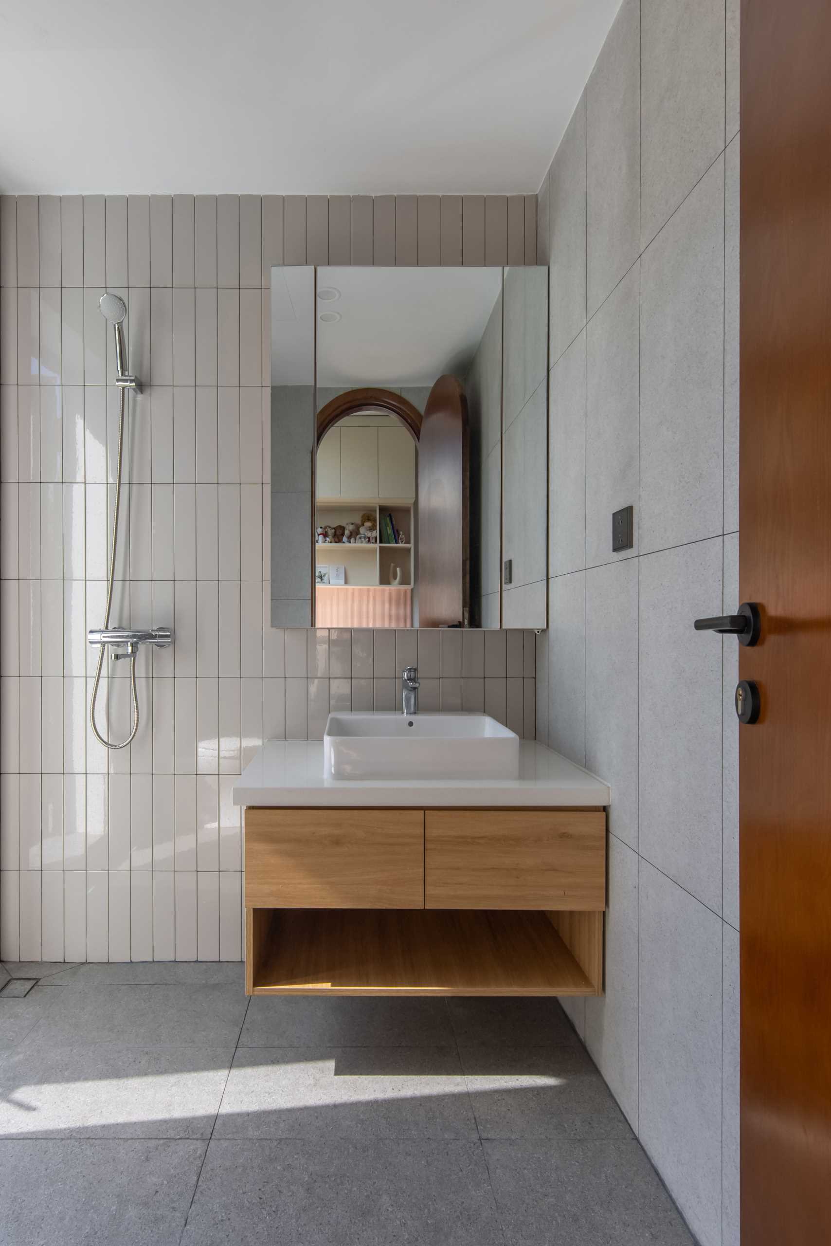 An ensuite bathroom includes a combination of tiles and an open shower.