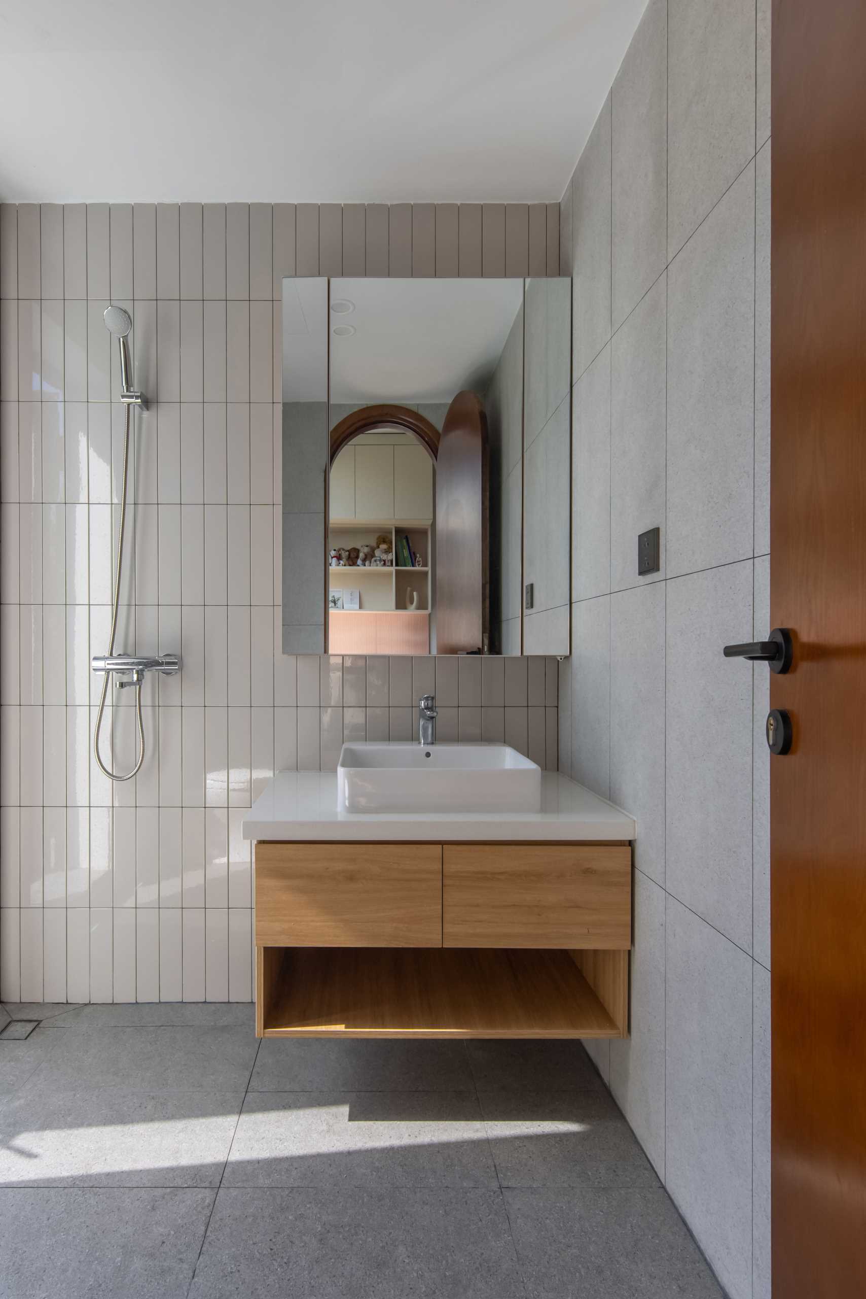 An ensuite bathroom includes a combination of tiles and an open s،wer.