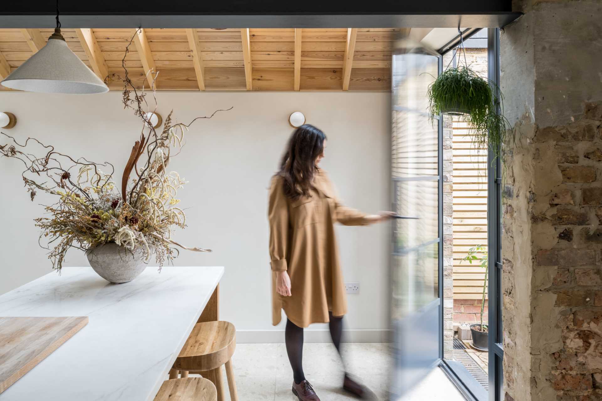 A new extension connects to the rear garden through a black-framed glass door.