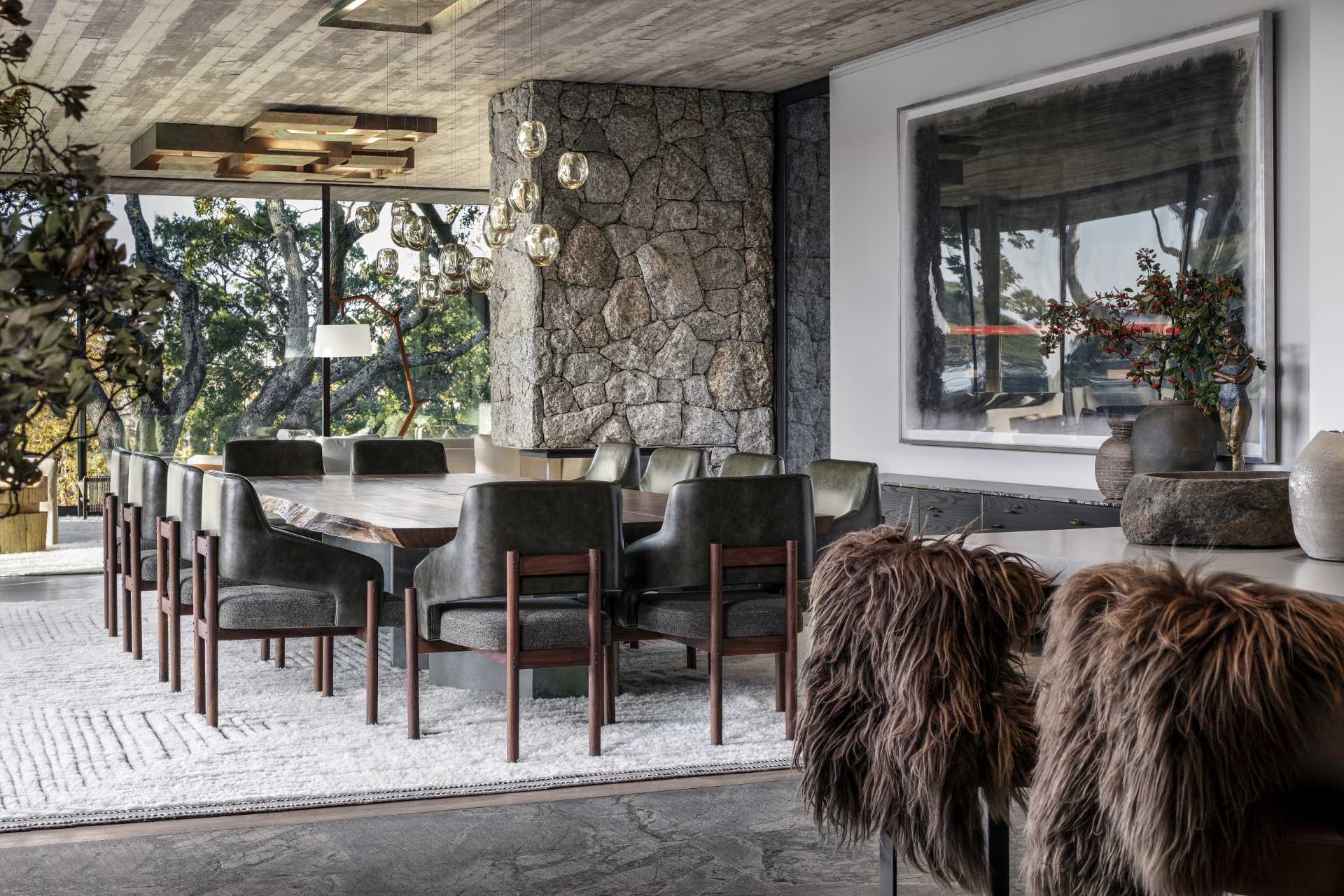 A modern dining area includes a custom-designed oversized oak table surrounded by black and wood chairs.