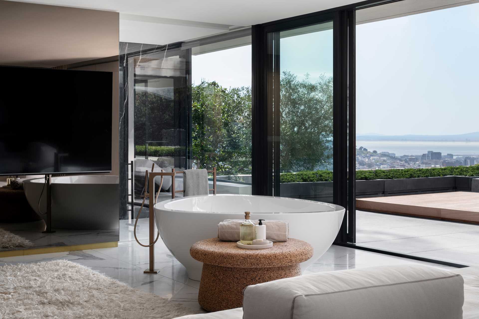 The main suite bathroom has a double vanity, a lounge area, and a freestanding bathtub with views of the city.