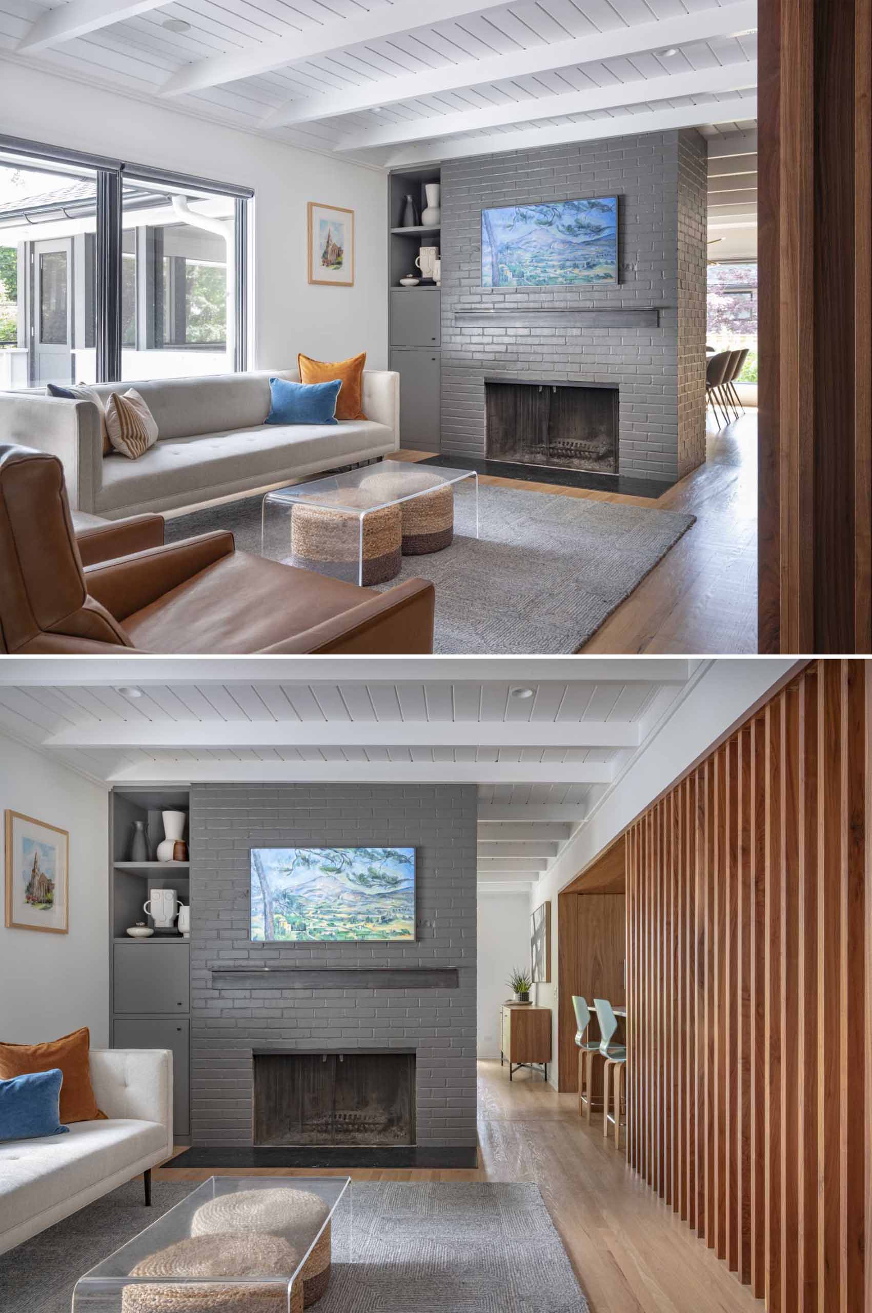 In the living room, stairs were added that lead down to a family room, while the white walls and ceiling, and the grey-painted brick fireplace reflect the colors used on the exterior of the home.