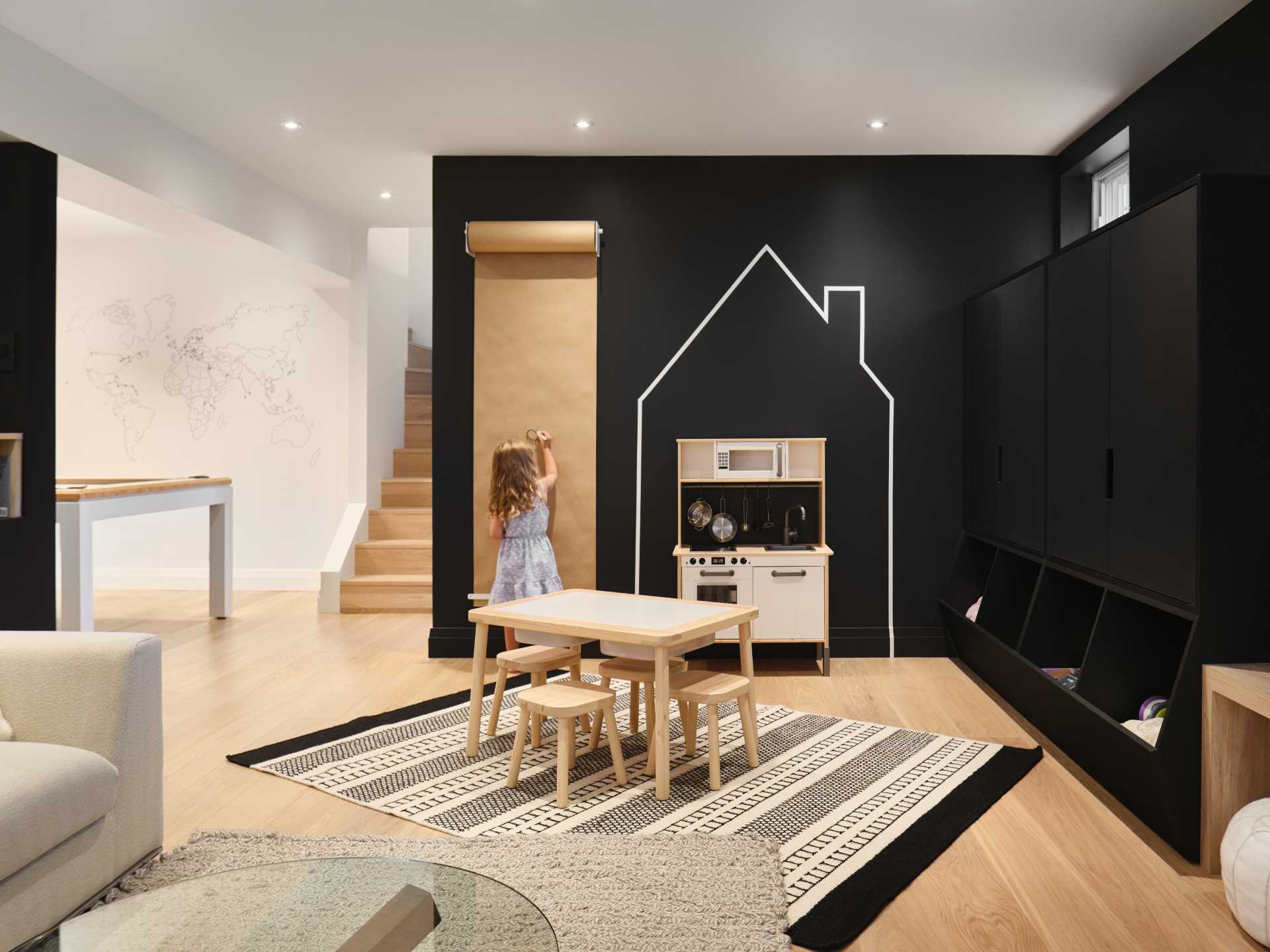 A modern basement with a playroom that has black walls.