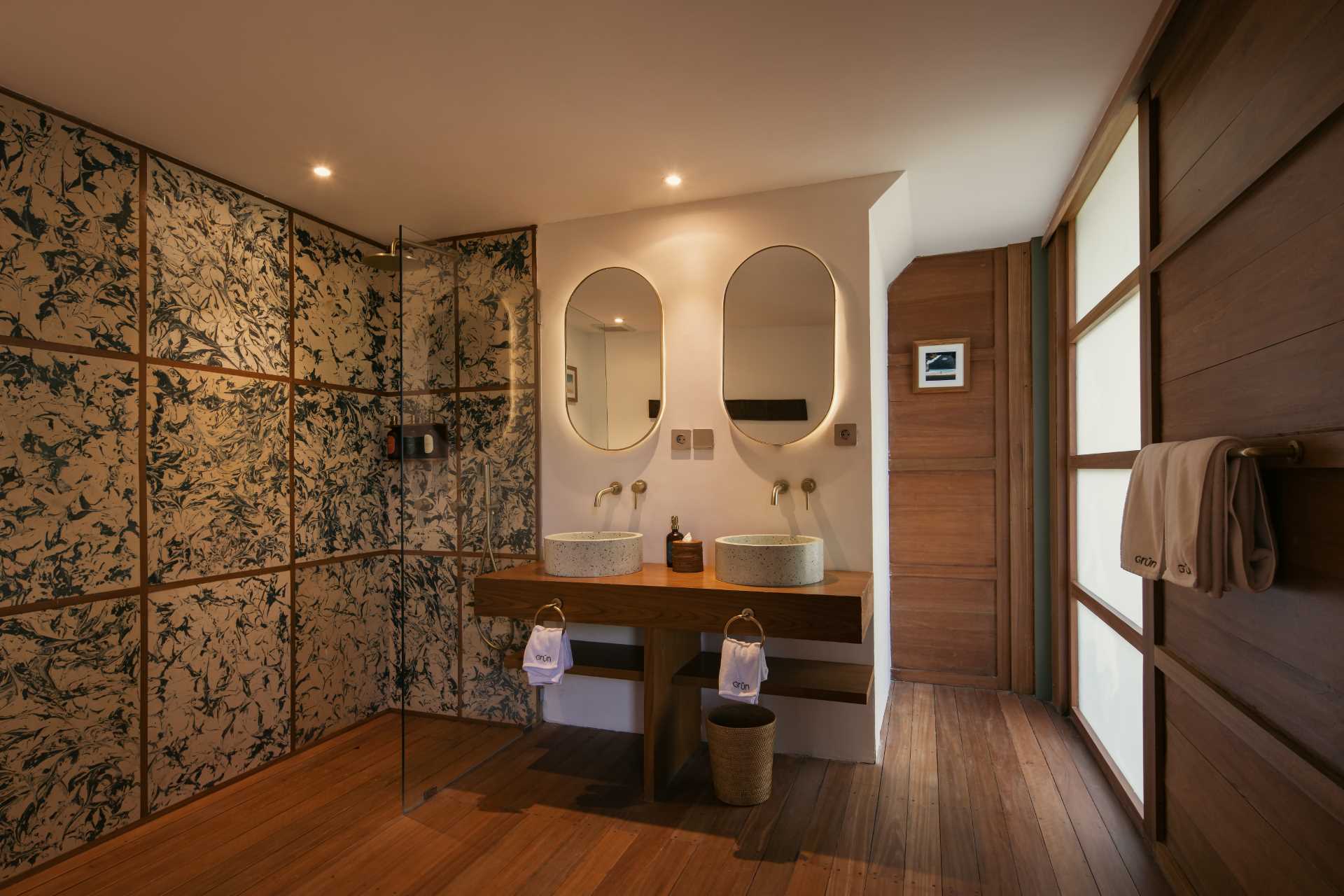 A modern bathroom with a double vanity and recycled plastic tiles that offer an artistic element.