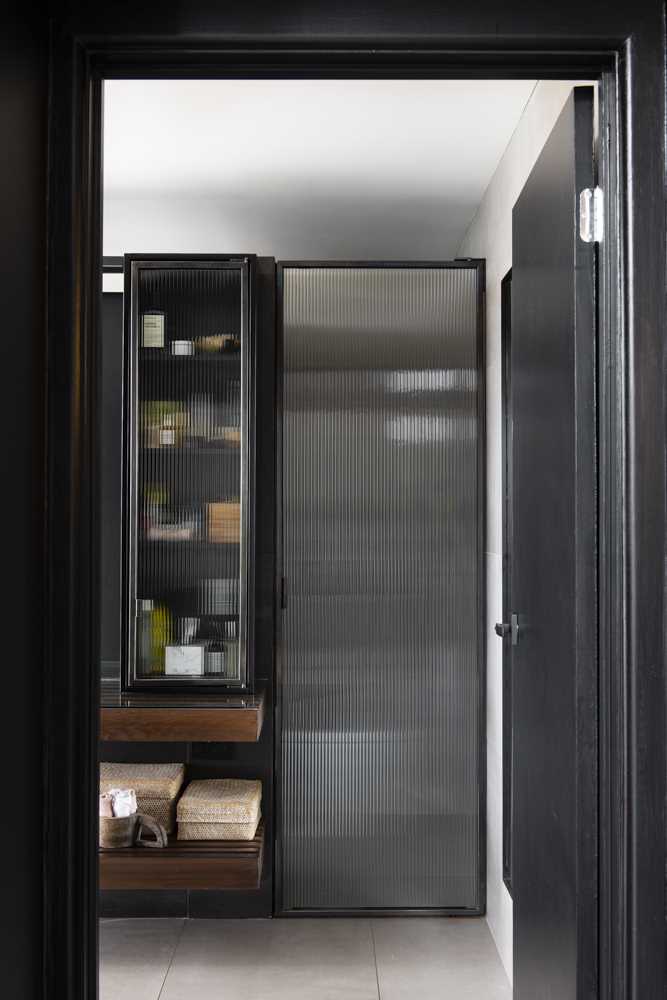 A modern bathroom with glass-fronted cabinets.