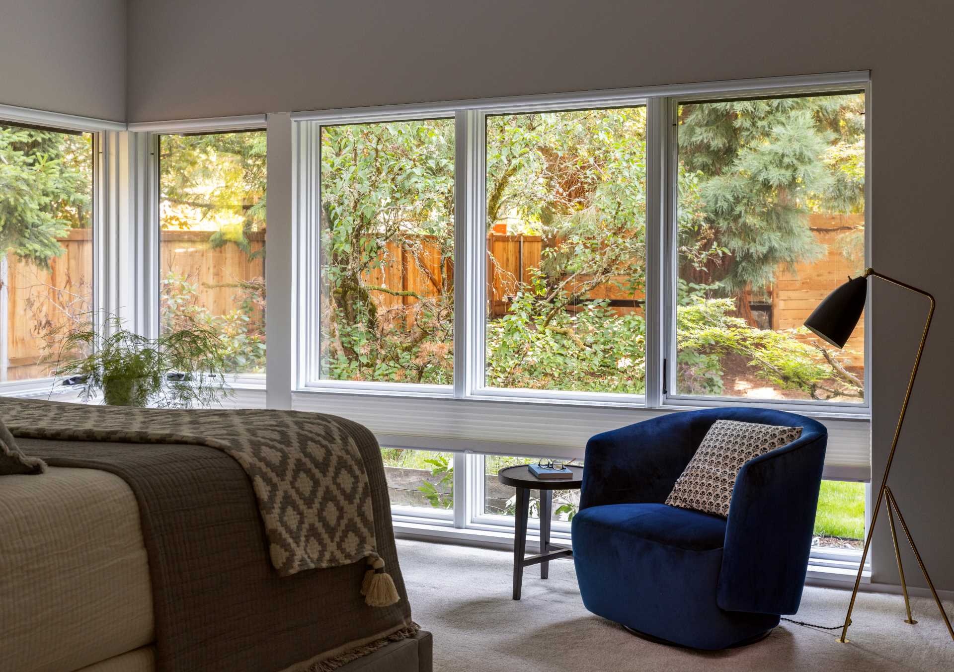 A contemporary bedroom with windows that wrap around the walls.