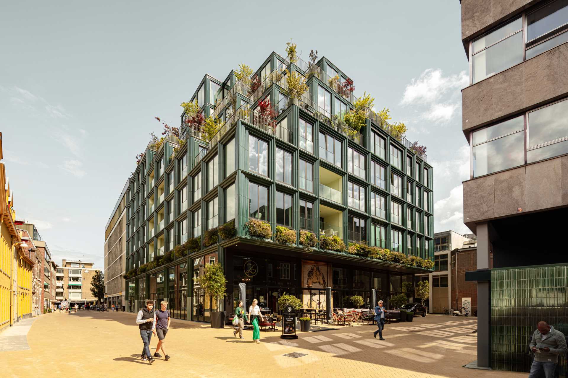 A modern building facade with glass and blue-green ceramic details.