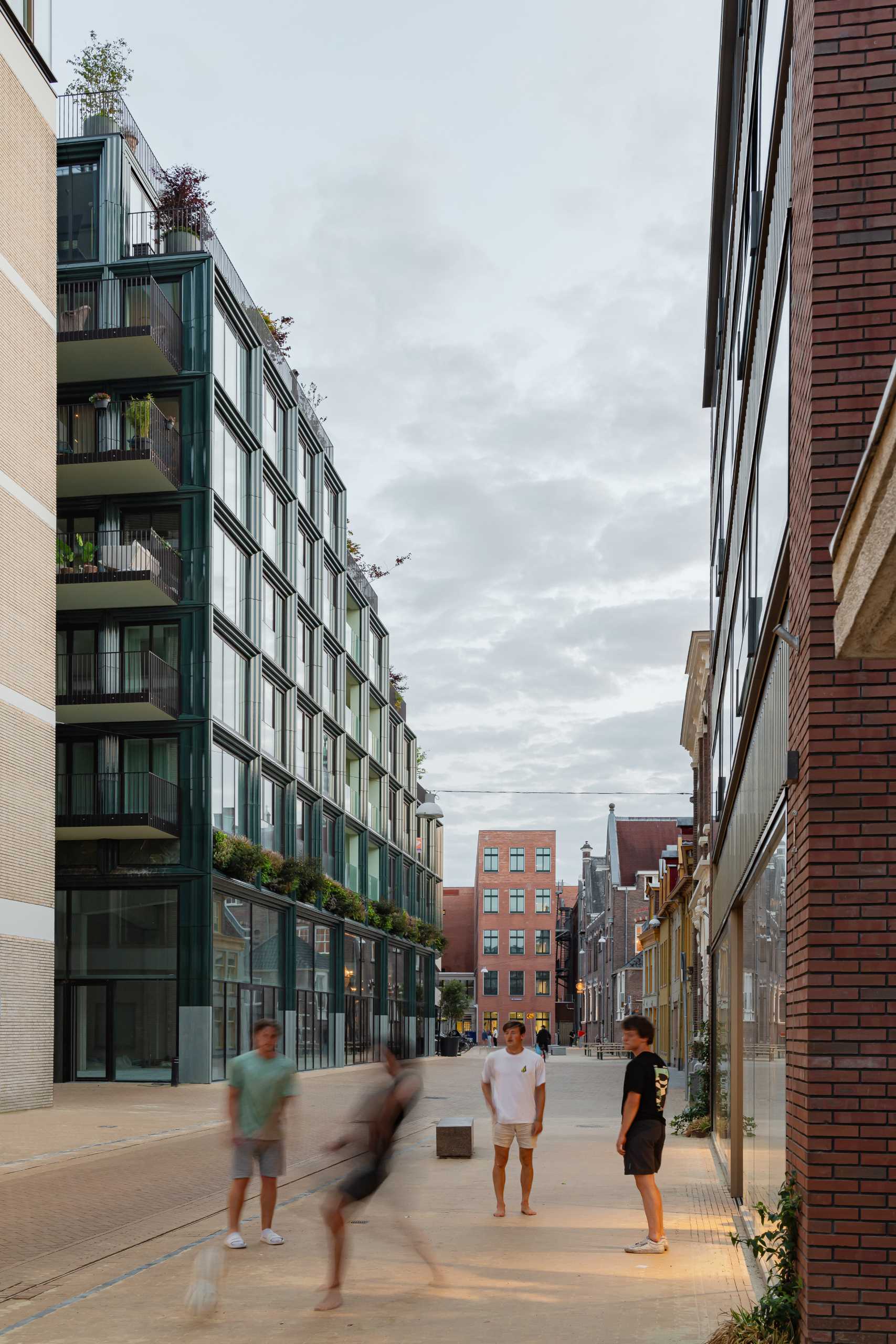 A modern building facade with glass and blue-green ceramic details.