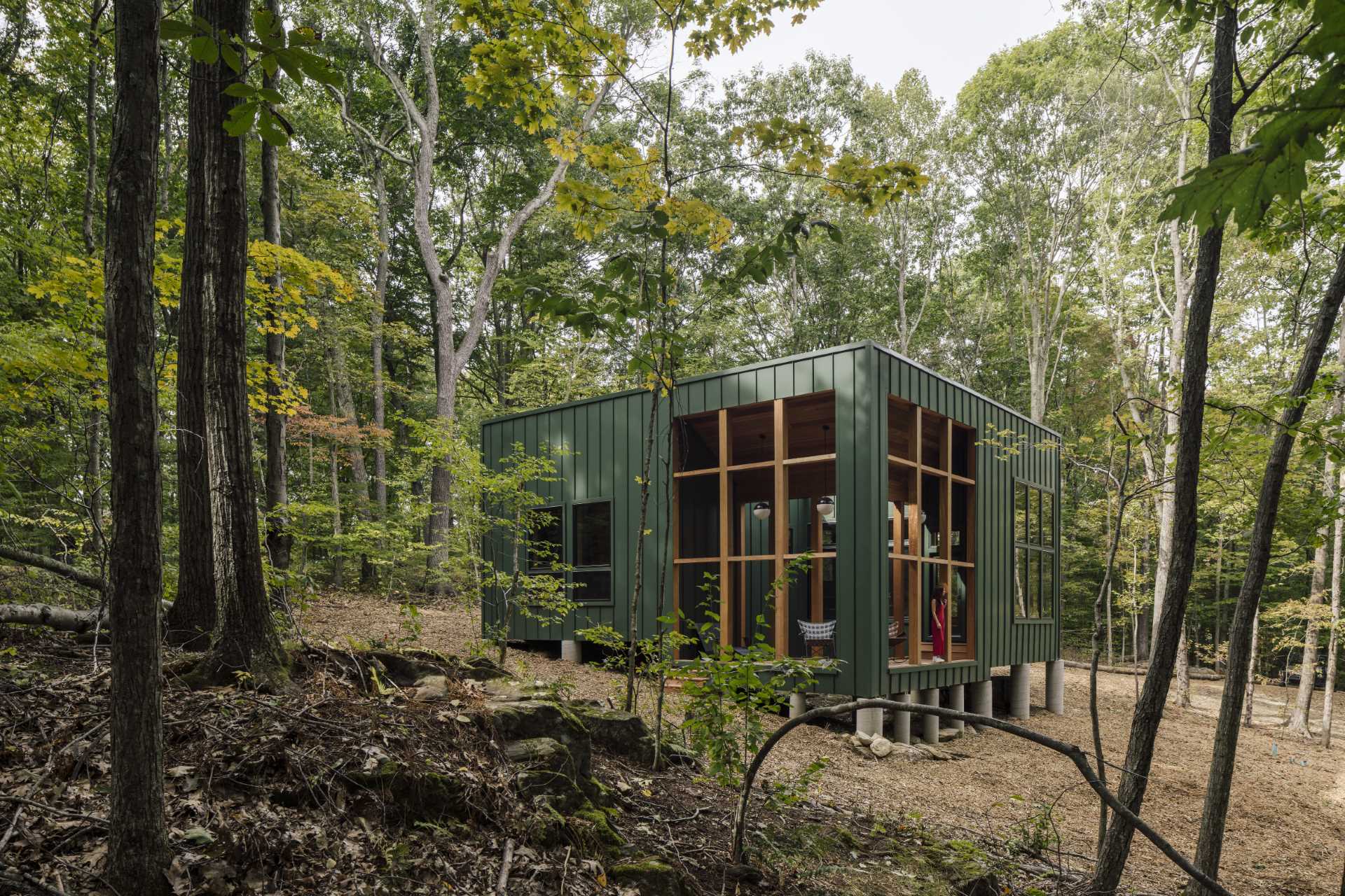 A modern two bedroom cabin with green metal standing seam siding and exposed wood structure.