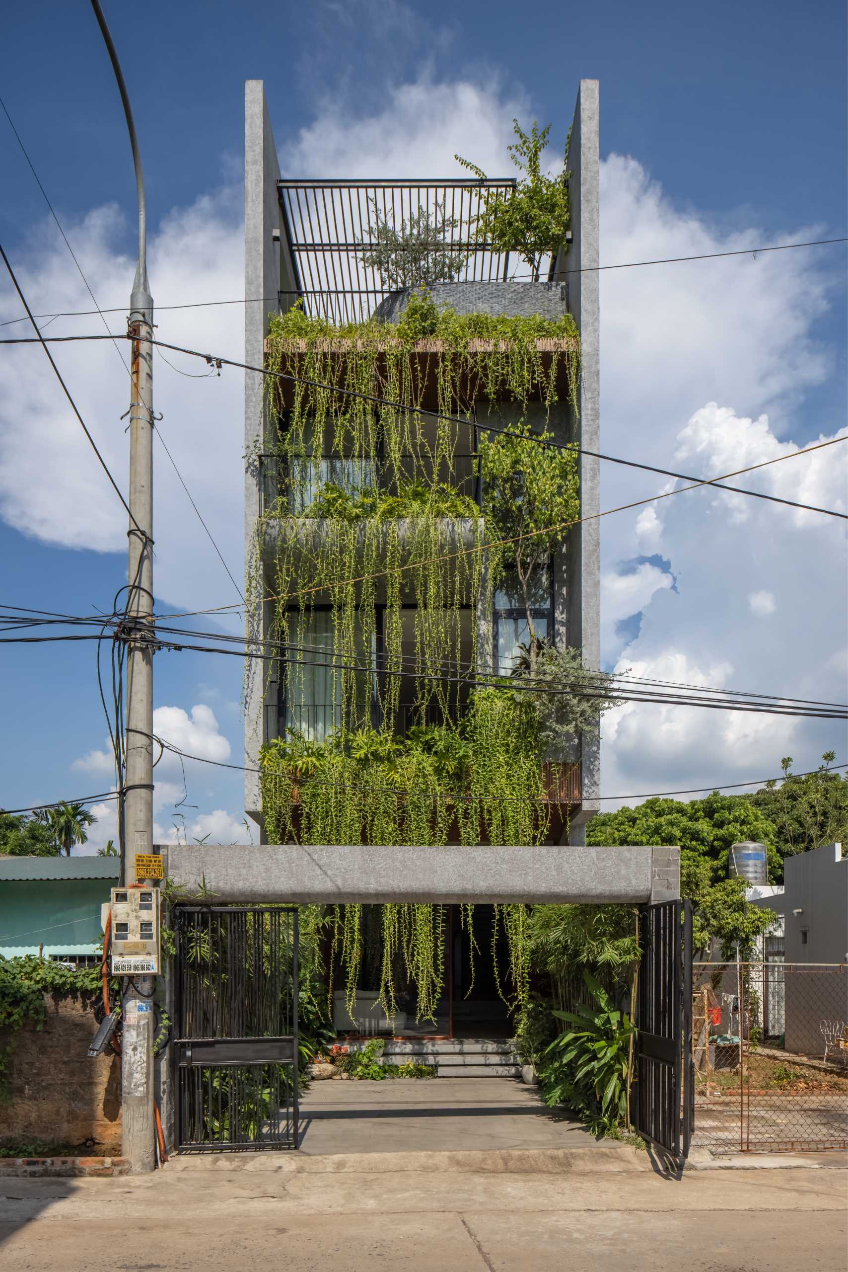 To integrate nature into the design of this modern home, Chrysanthemum curtains have been planted on the balconies, helping to soften the exterior and solve the problem of heat radiation, as well as the hot dry wind. The plants also assist in shielding the interior from the rain.