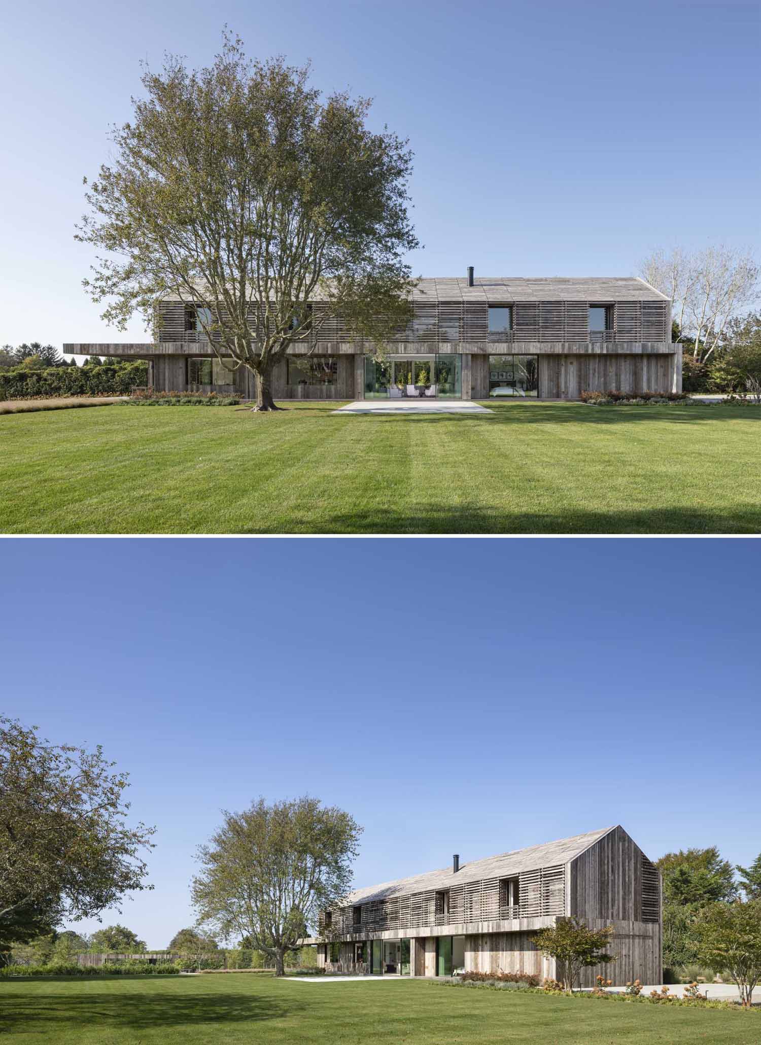 A modern two-story gabled home is clad in reclaimed weathered wood siding.