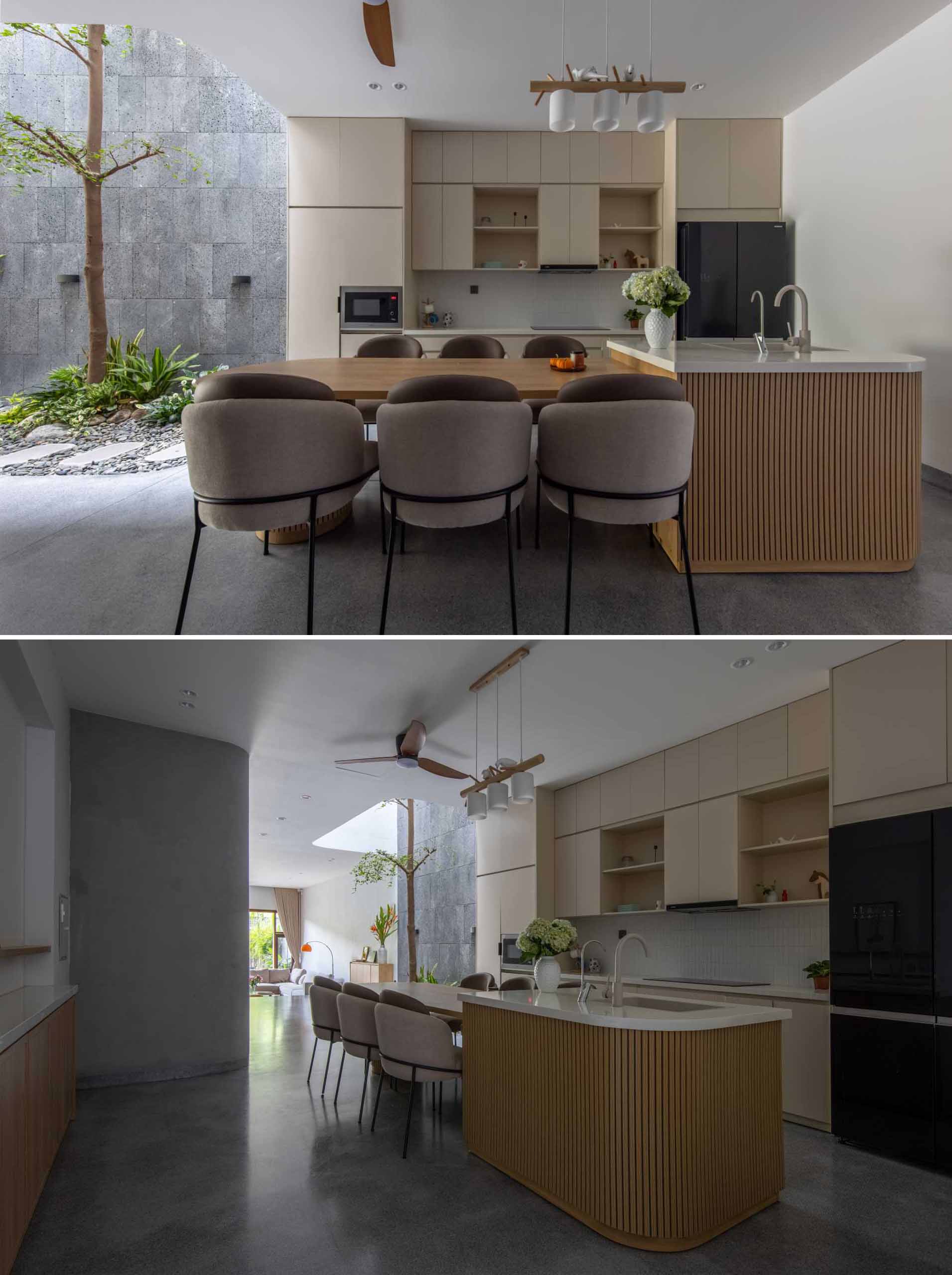In this modern home interior, the dining area and the kitchen are combined, with the dining table integrated into the island.