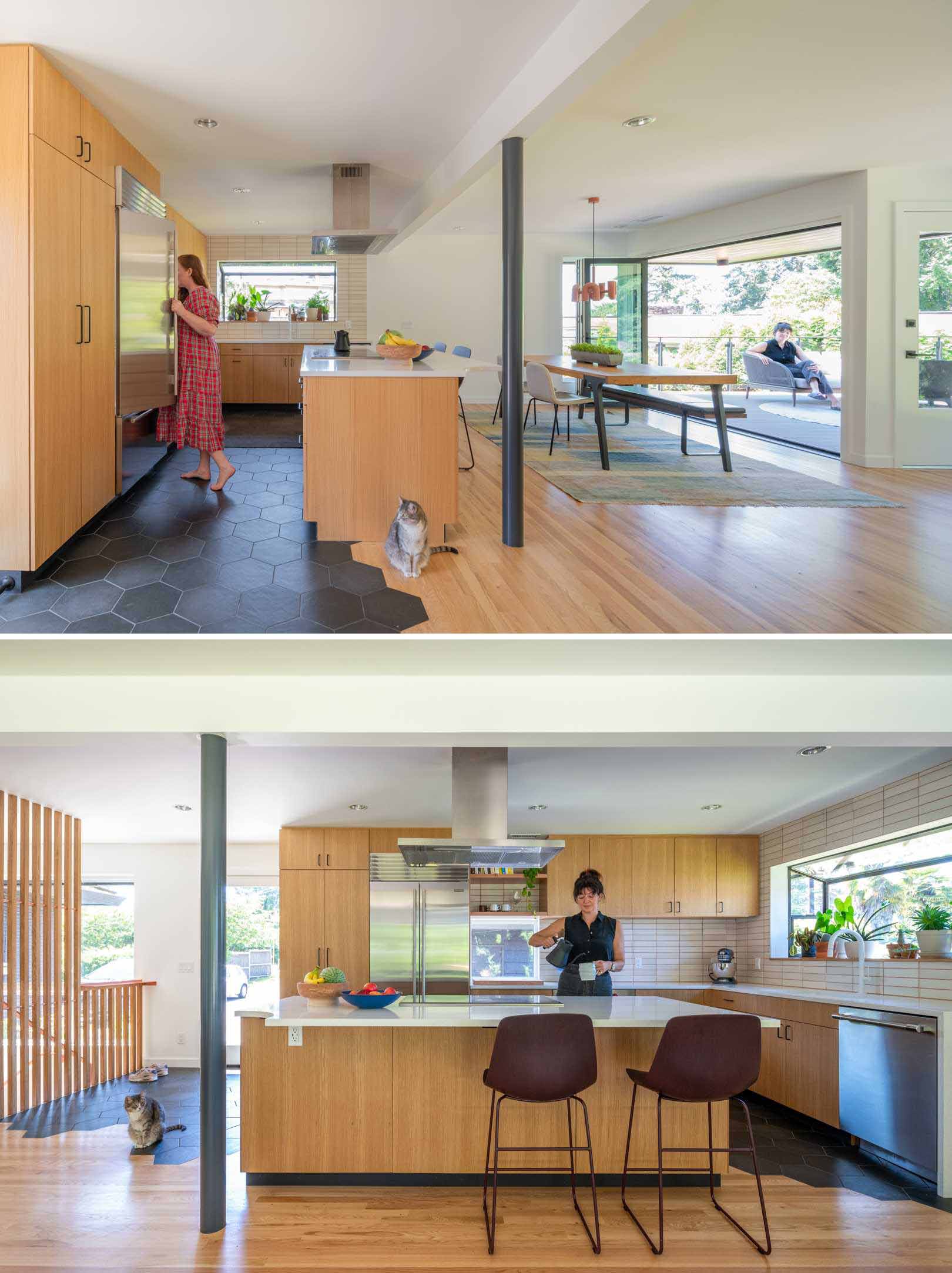 This newly renovated kitchen is completely open to the dining area, and now includes minimalist wood cabinets and an island. Dark hexagonal tiles have been used for flooring to define the kitchen and entryway.