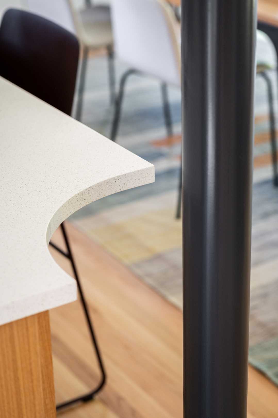 A kitchen island with a curved cut-out for the structural support that allowed the kitchen to be opened up to the dining area.