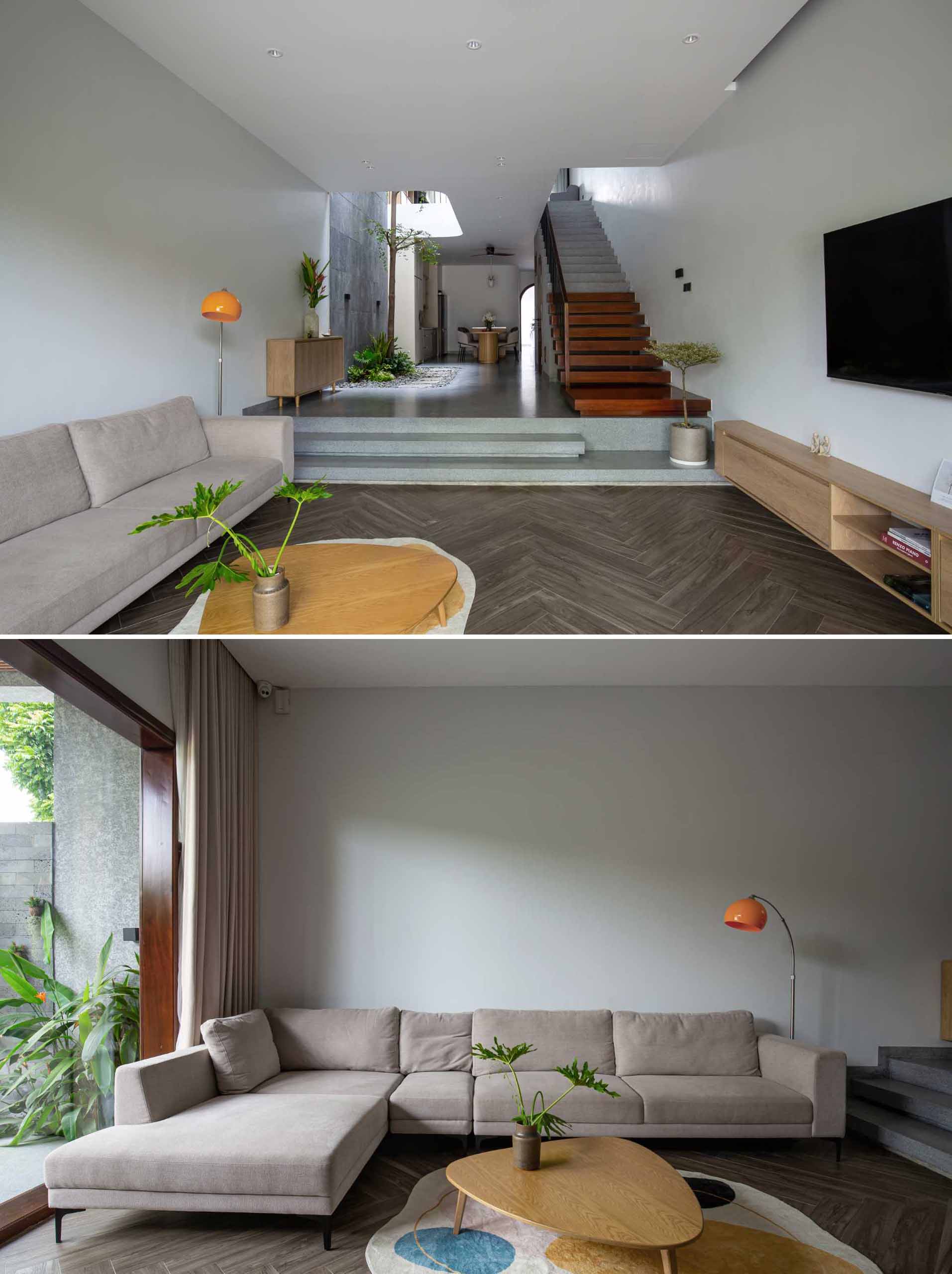 Stepping inside this modern home, there's the living room with a couch on one side and a floating entertainment unit underneath the TV.