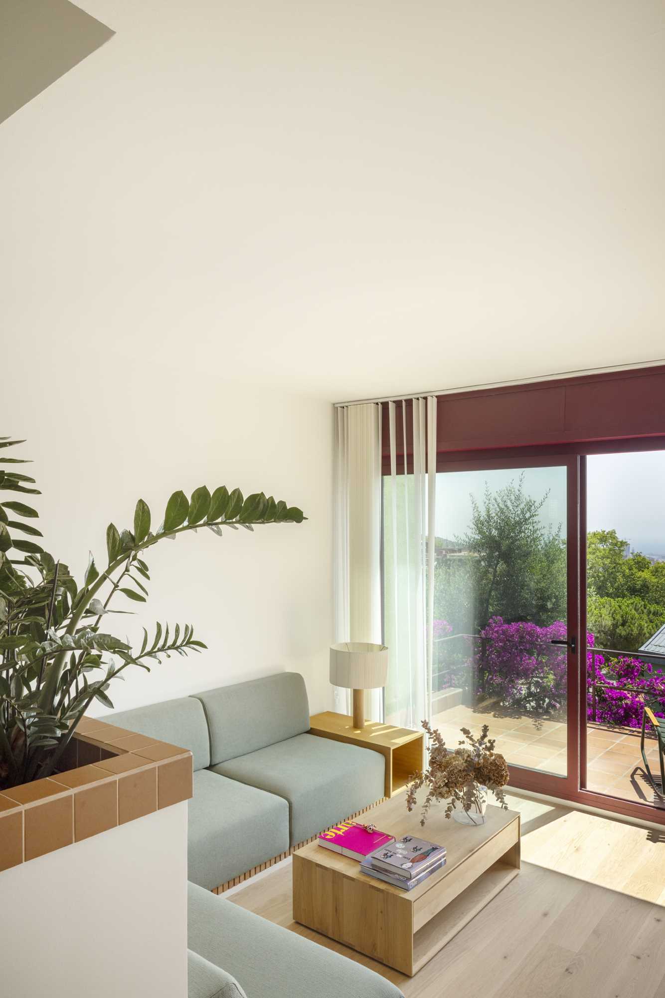 A contemporary home interior with split-levels that include built-in planters and a green couch in the living room.