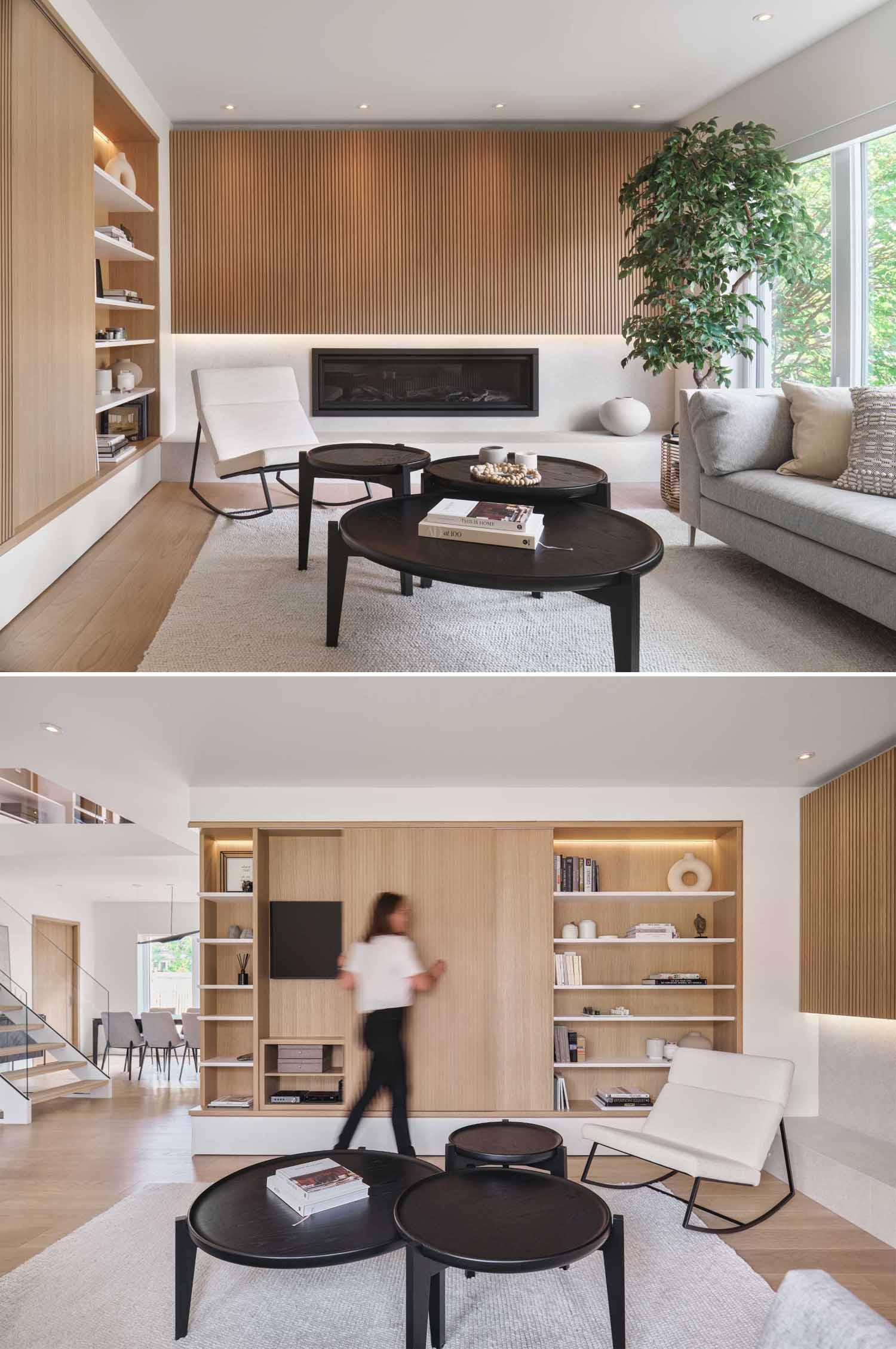 In this modern living room, a wood accent wall is highlighted above the fireplace, while shelving flanks either side of the TV wall, which has a sliding panel to hide the TV.