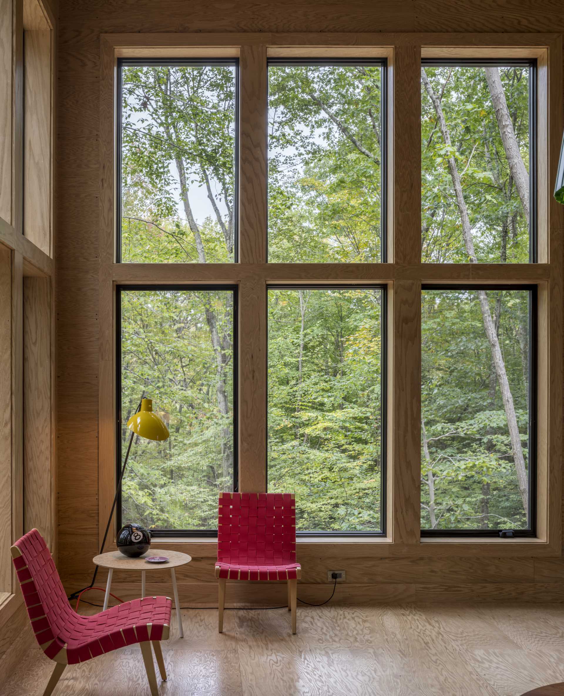 A modern living room with a wall of windows in a two bedroom cabin.