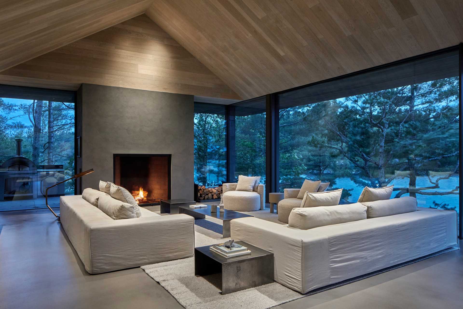 At the heart of this modern cottage is an open-concept living and dining area framed by a vaulted ceiling encased in hand-brushed European oak boards.